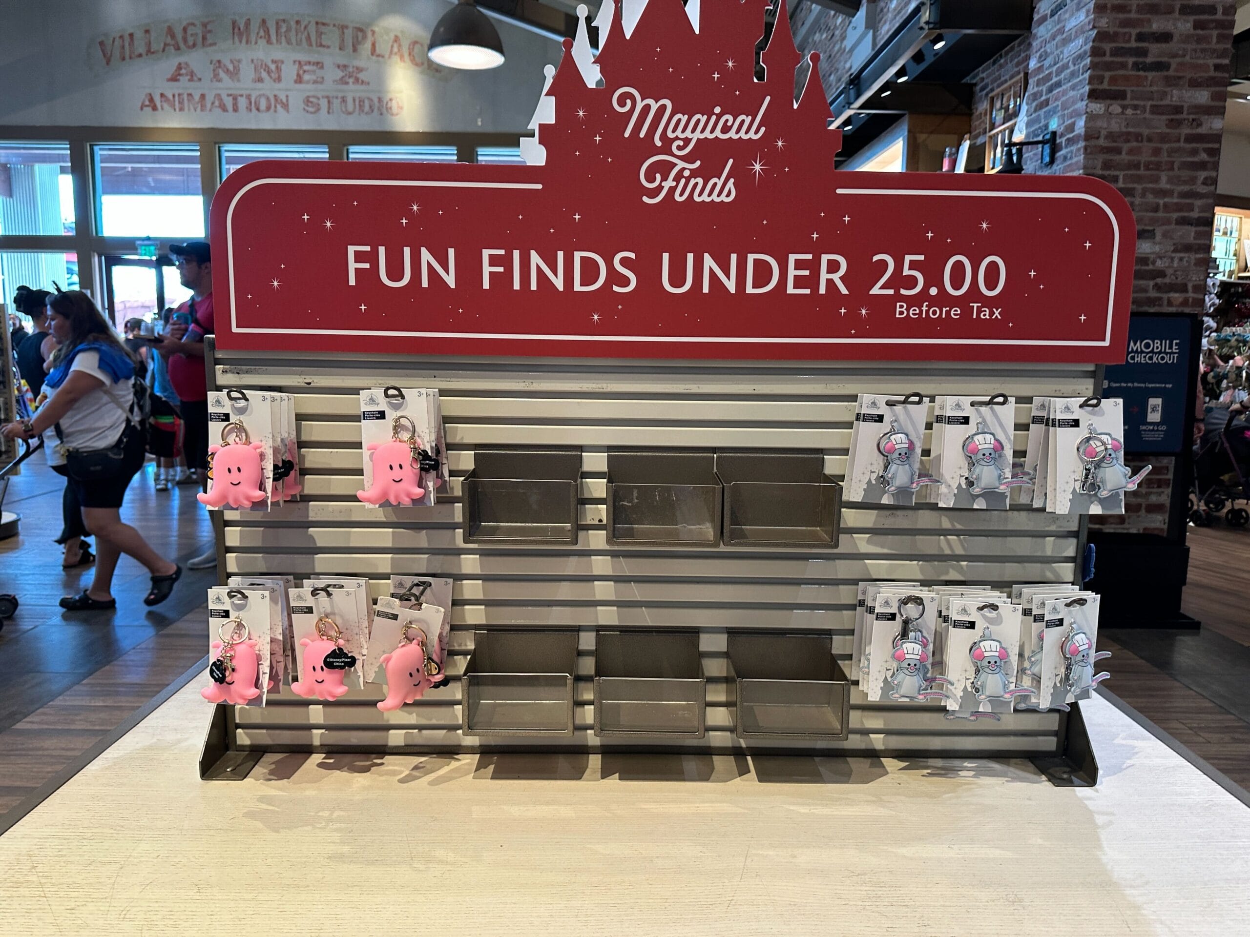 Store display with a red sign reading “Fun Finds Under 25.00,” holding a few small plush toys and keychains.