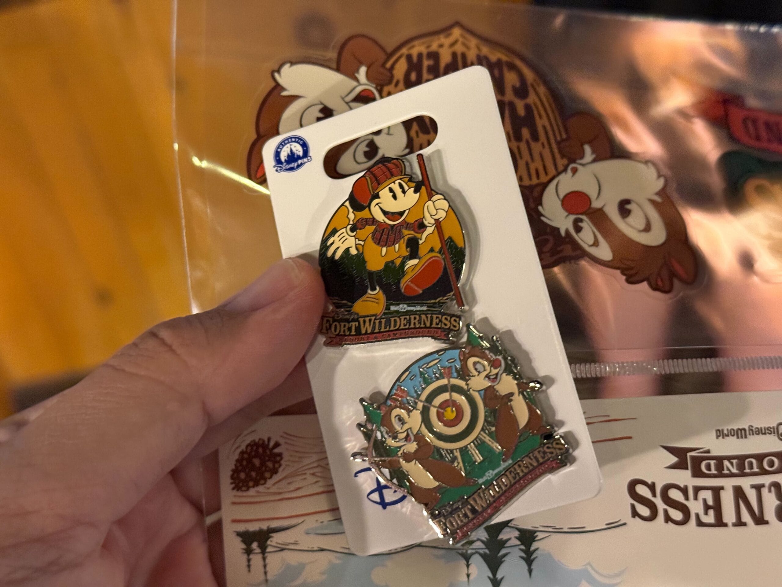A hand holds two new arrivals: Disney’s Fort Wilderness merchandise pins of Mickey Mouse and Chip and Dale on a backing card.