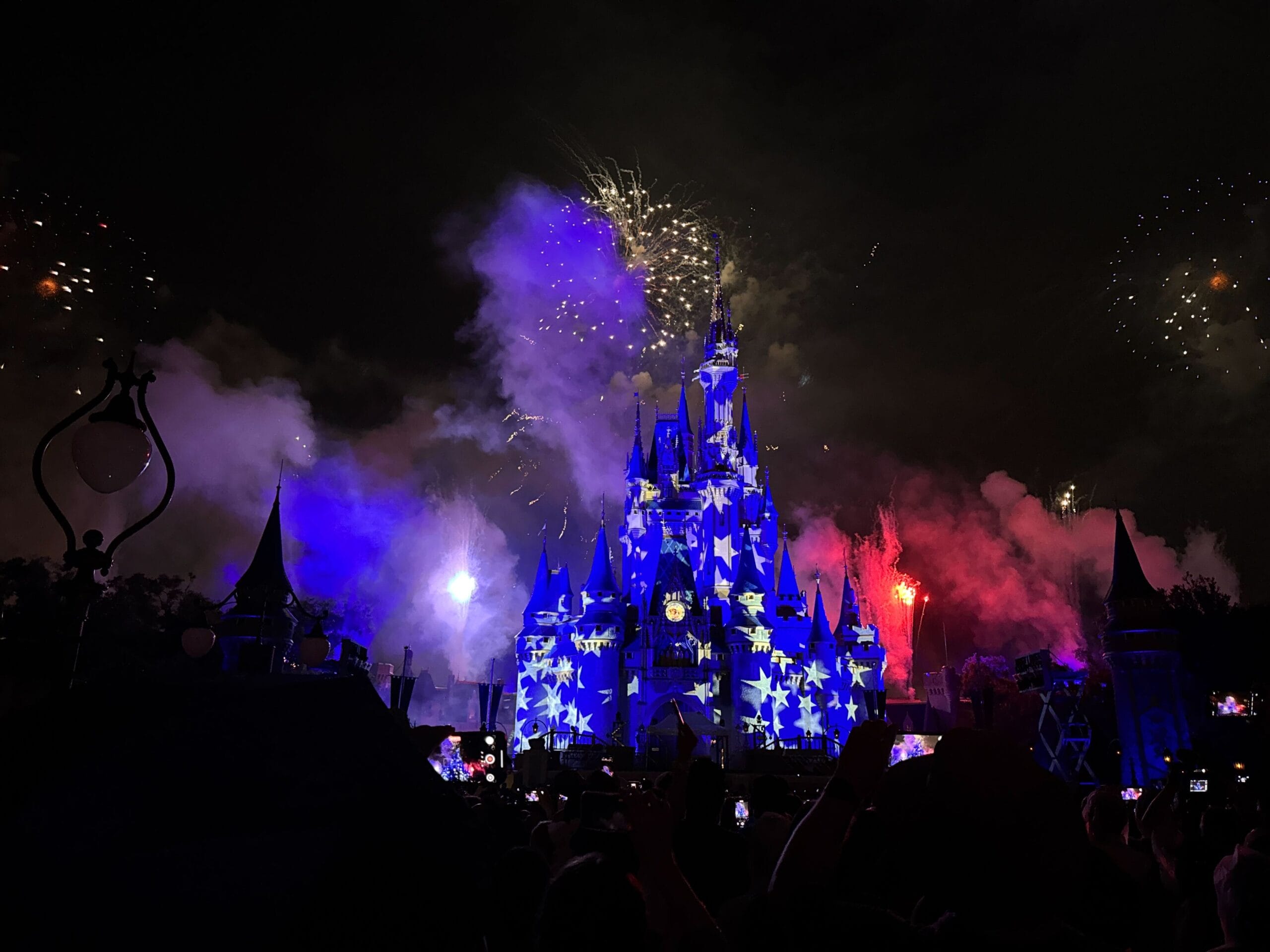 Cinderella Castle at night shines with blue stars and fireworks, the perfect place to celebrate America.