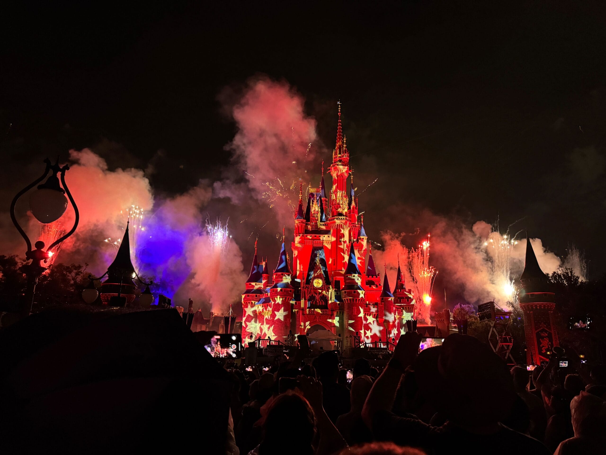Disney castle illuminated in red, white, and blue lights as fireworks celebrate America on the Fourth of July 2025.