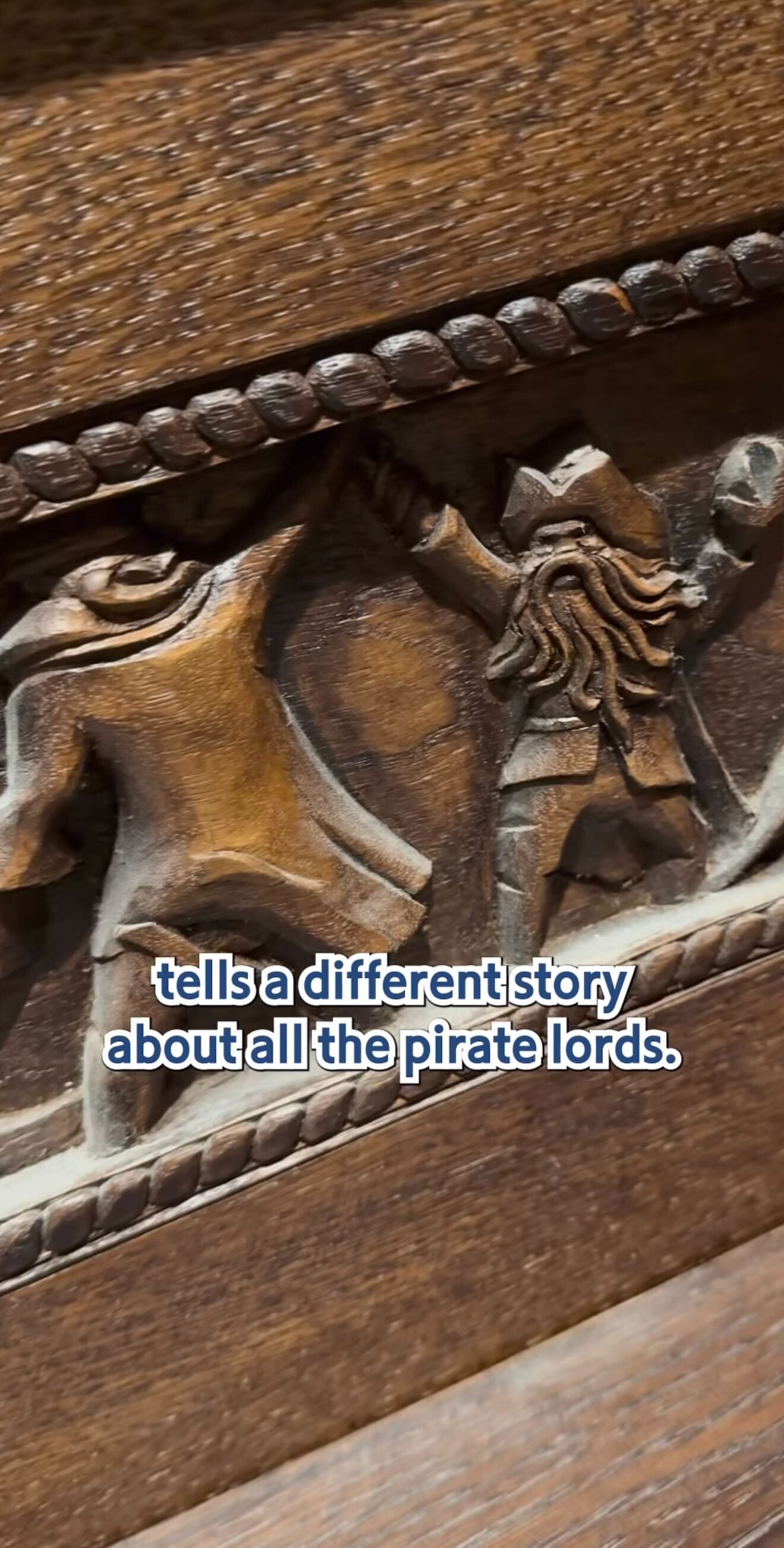 A wooden carving shows a pirate with an outstretched arm beside a horse at The Beak and Barrel, with rope-like trim above and below.