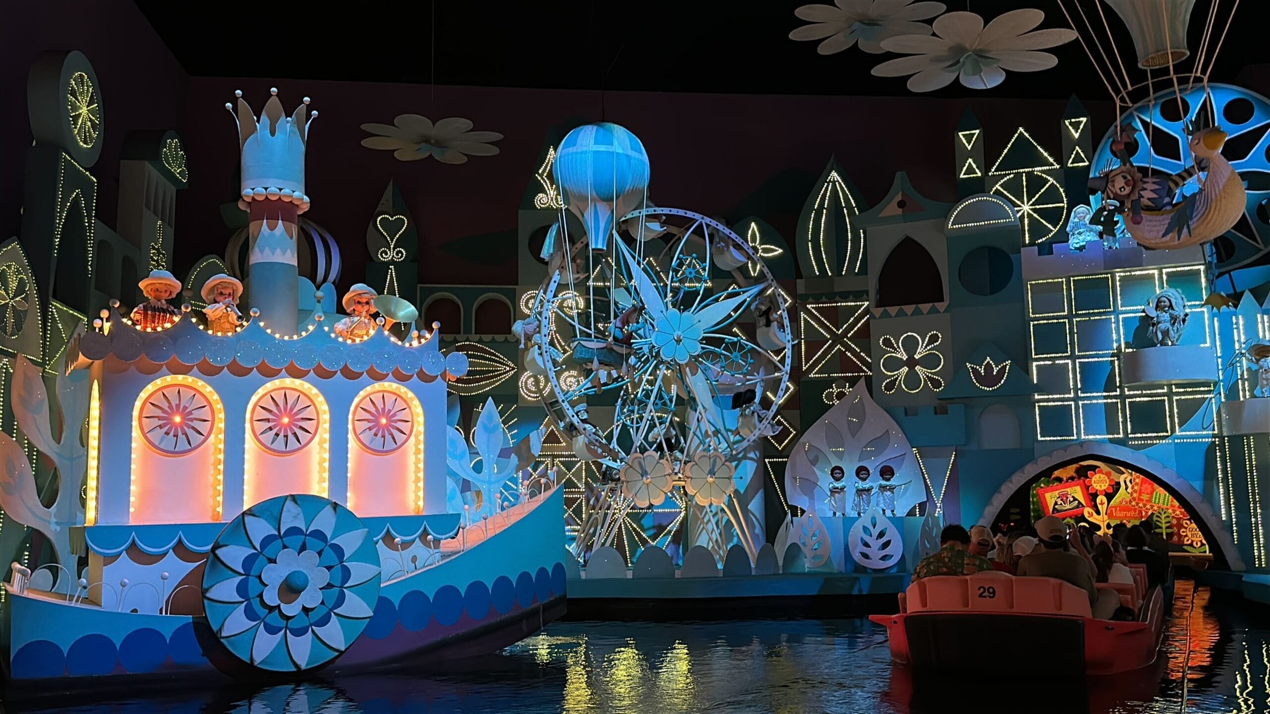 Colorful Magic Kingdom "it’s a small world" ride scene with animated dolls, ferris wheel, and whimsical illuminated decor.
