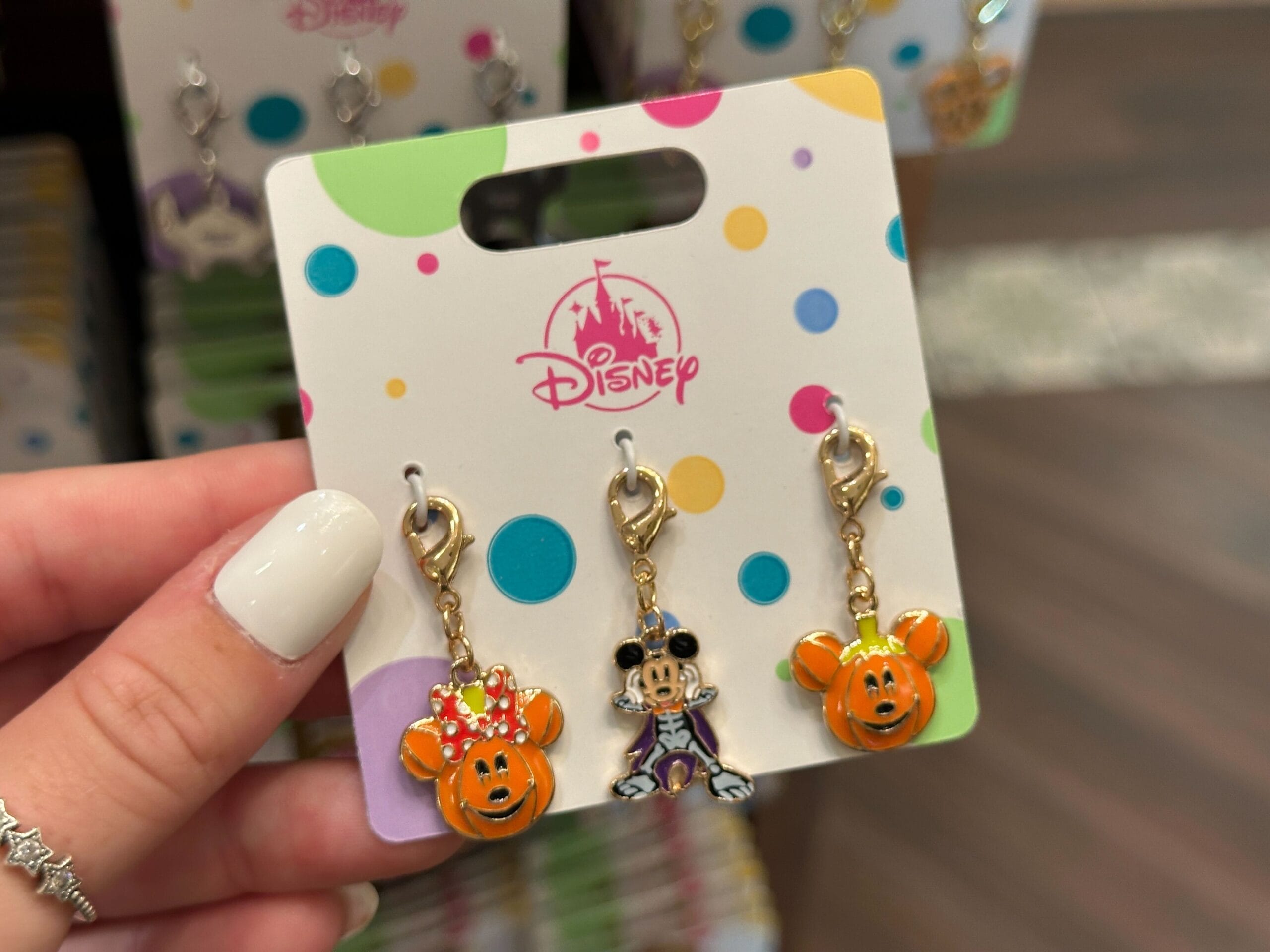 Three Disney-themed Halloween keychains on a colorful display card; two orange pumpkins and one Mickey Mouse in costume.