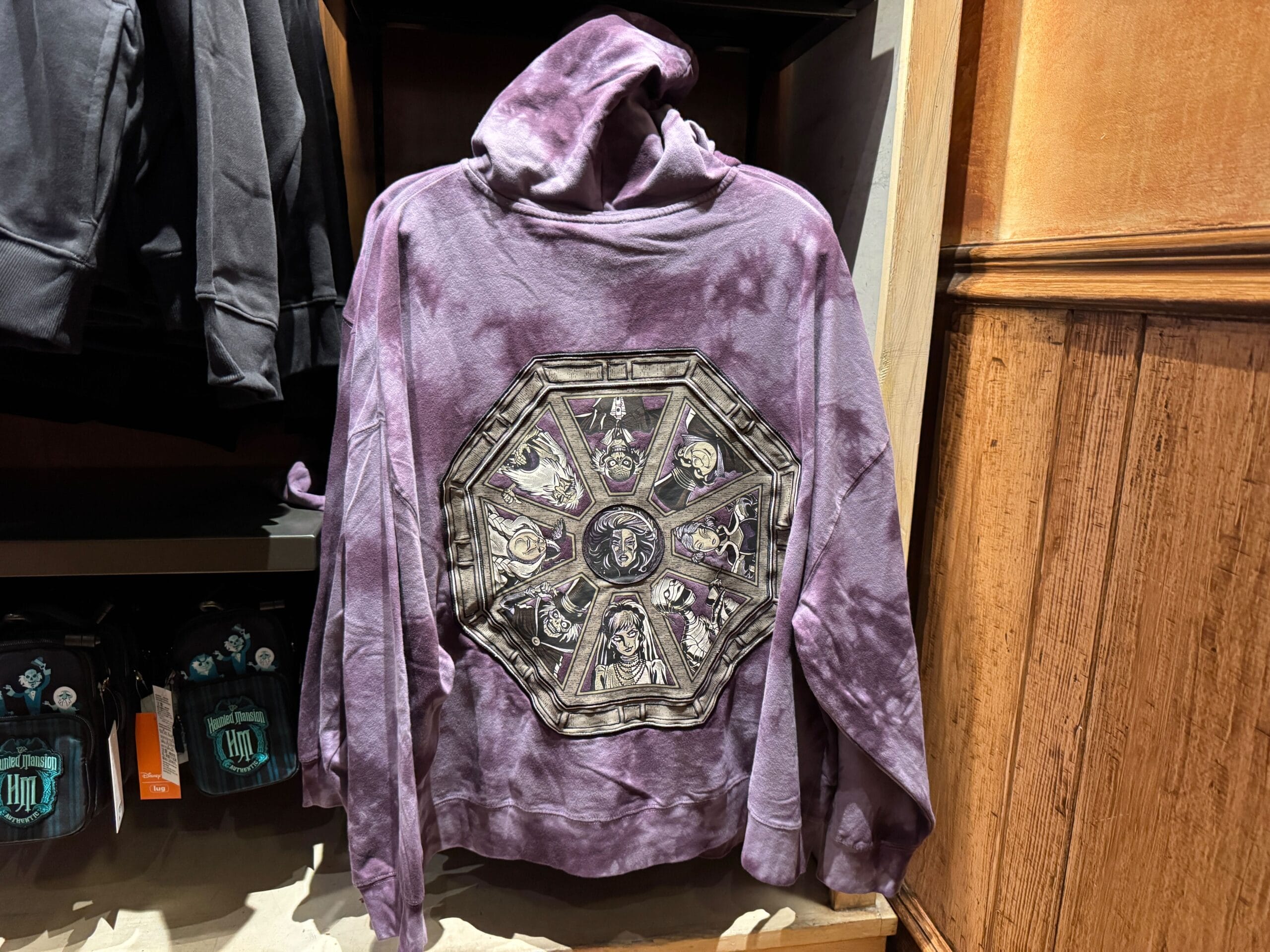 Purple hoodie with a large octagonal graphic inspired by Haunted Mansion portraits, perfect Magic Kingdom merch.