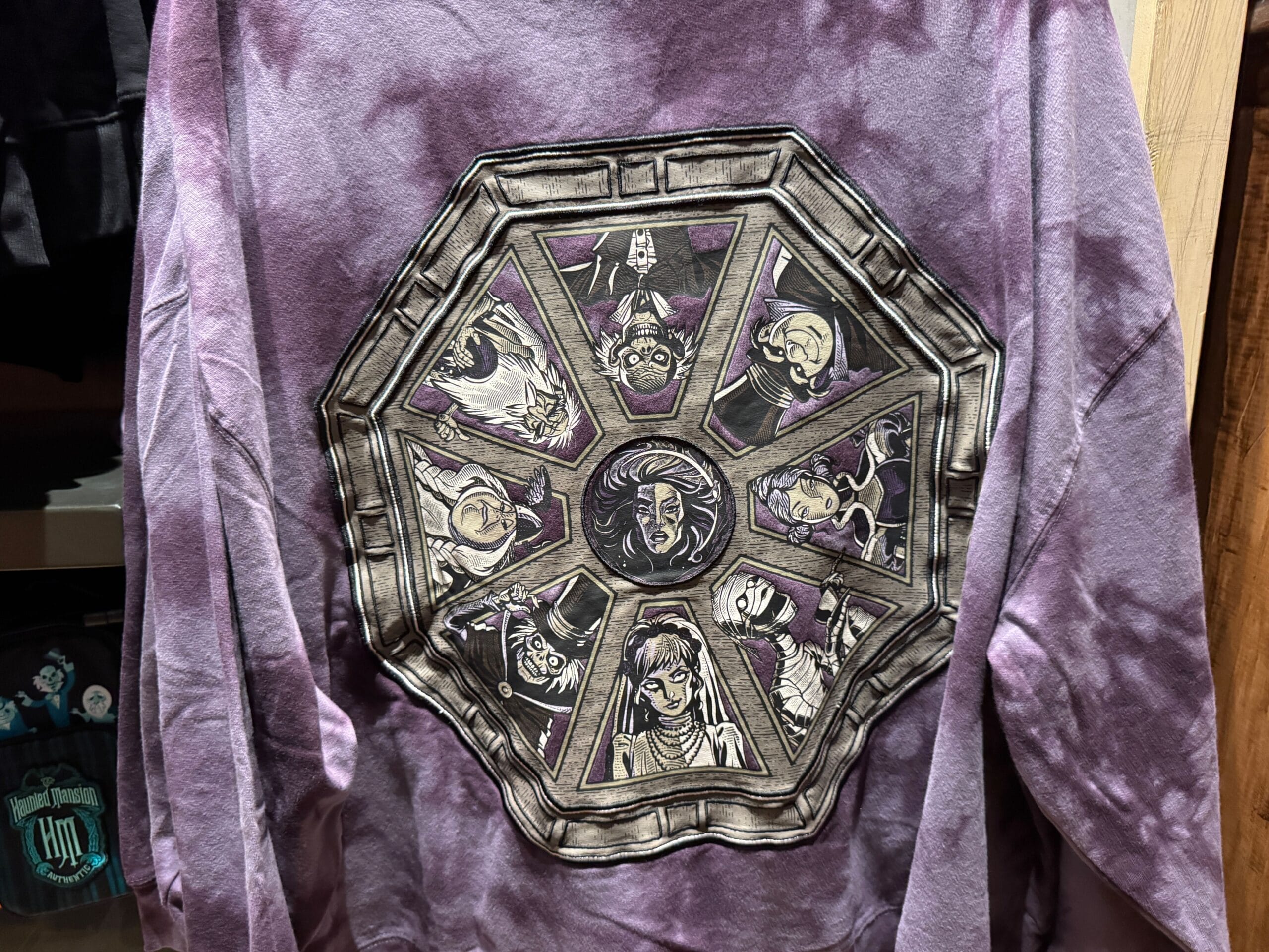 Purple tie-dye shirt featuring Magic Kingdom's Haunted Mansion characters in an octagonal frame on the back.