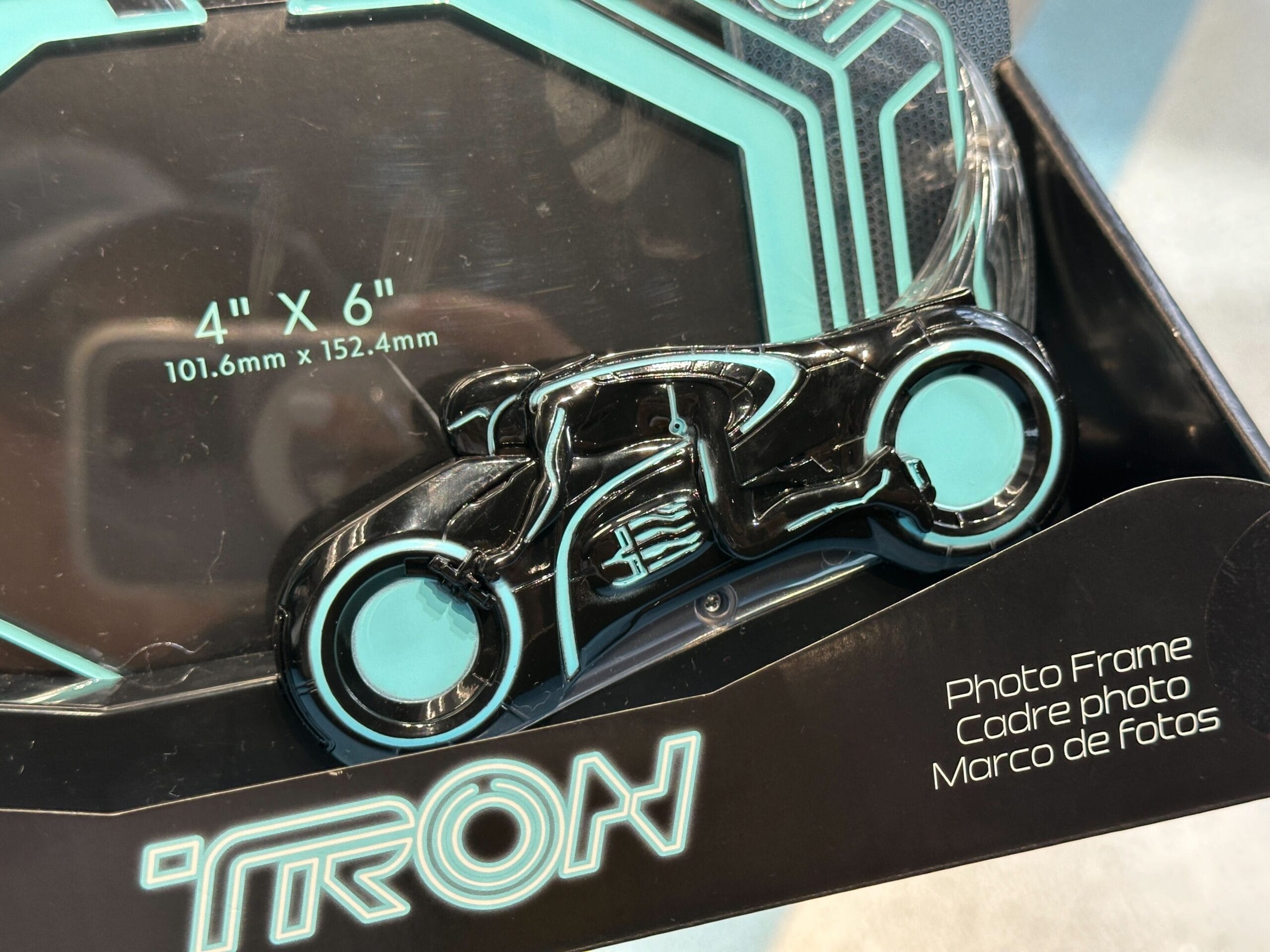 A Tron-themed photo frame with a blue and black light cycle design, sized for a 4" x 6" photo.