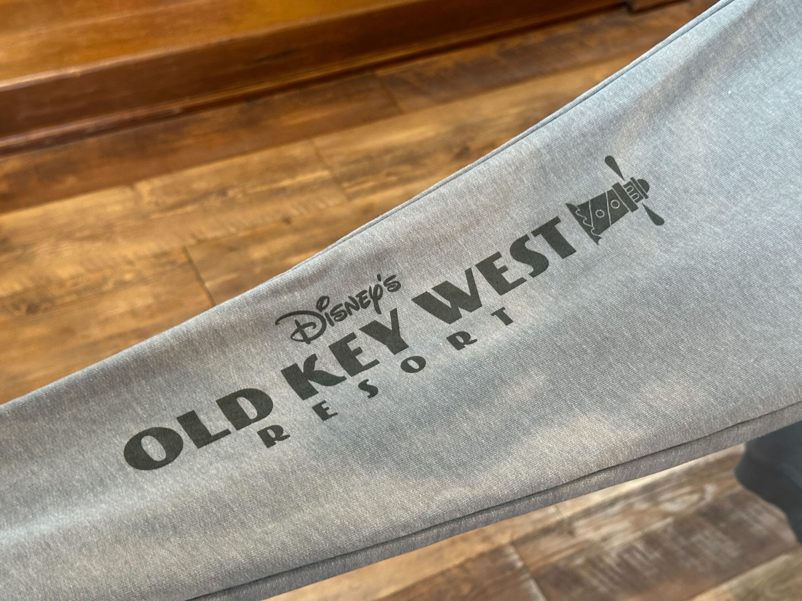 Gray Disney Vacation Club apparel featuring the Old Key West Resort logo and crossed keys, displayed on a wood floor.