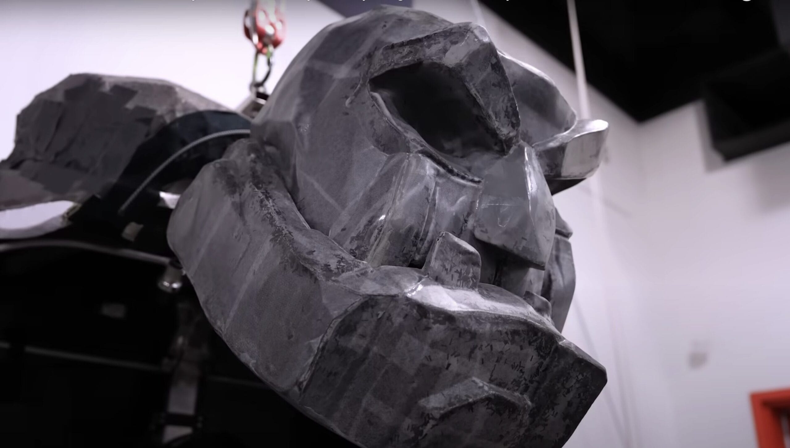A large, gray, robotic head sculpture—reminiscent of Disney Cruise Line's Hercules stage show—hangs from the ceiling.