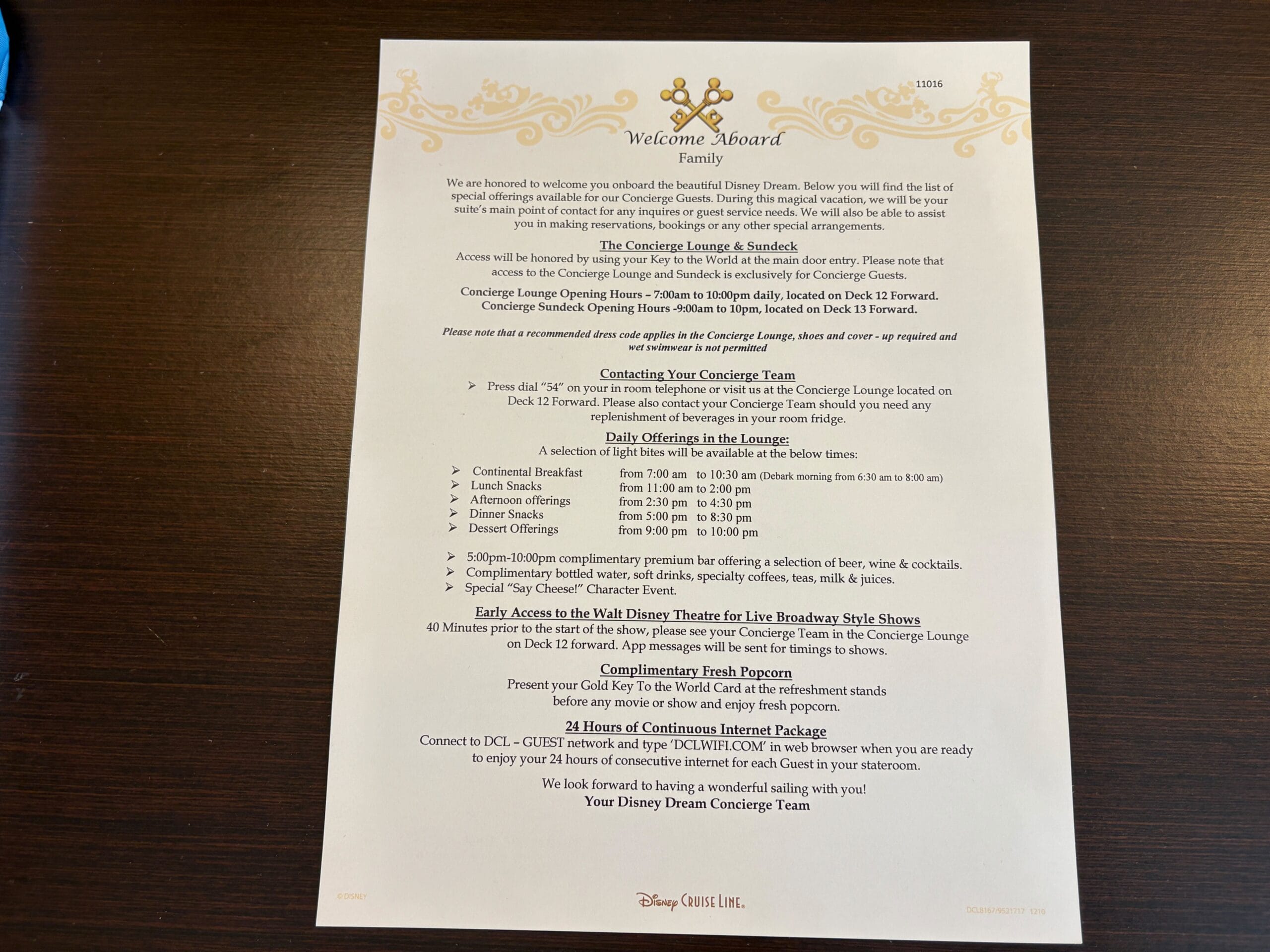 A Disney Dream welcome letter for Concierge Family Oceanview Stateroom guests sits on a wooden table.