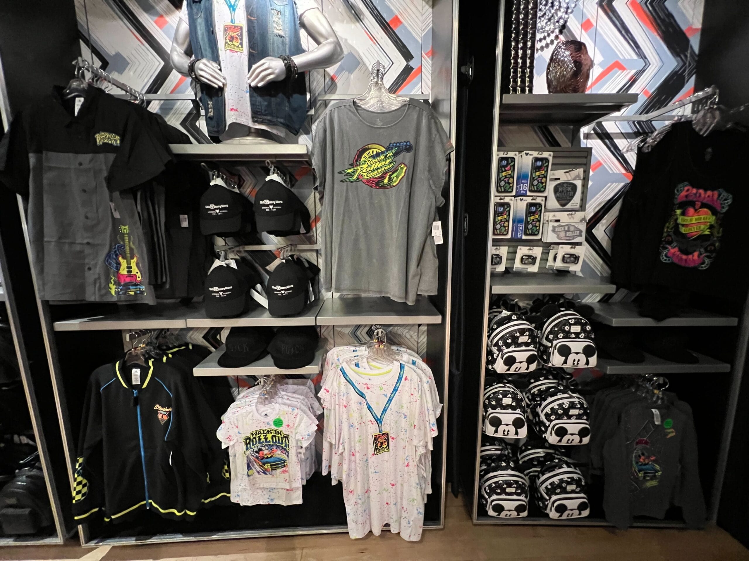 Display shelves with Rock 'n' Roller Coaster apparel, hats, hoodies, and phone cases at Disney's Hollywood Studios.