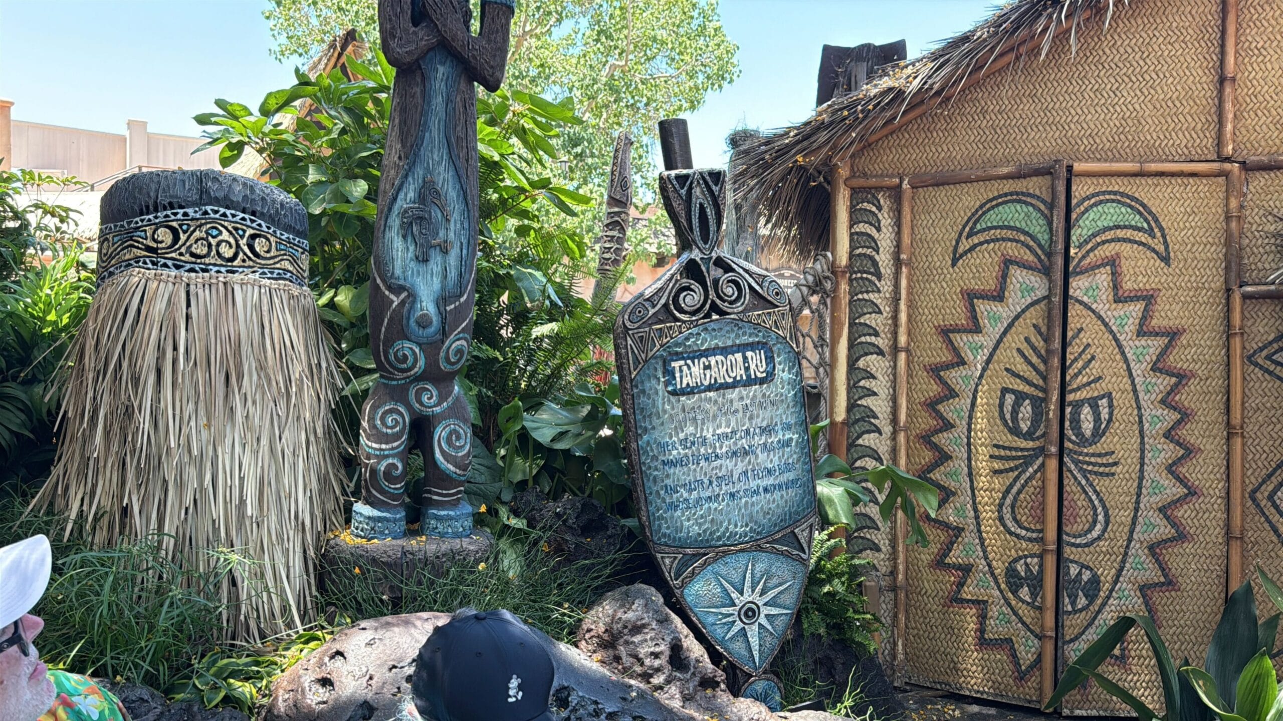 Polynesian-style tiki statues and a thatched hut evoke the Enchanted Tiki Room at Disneyland.