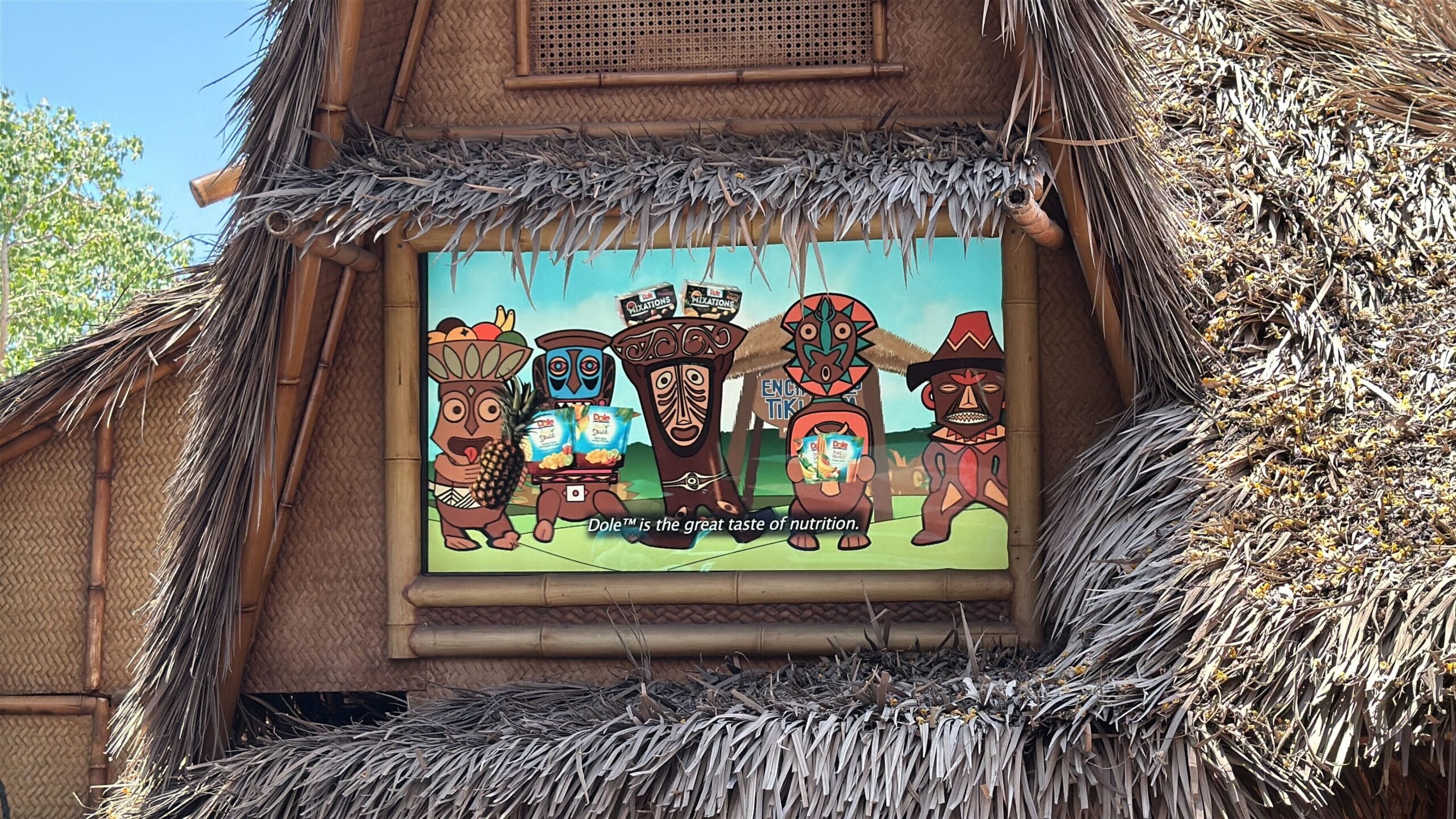 A colorful tiki-themed sign at Disneyland’s Enchanted Tiki Room reads, "Dole is the great taste of nutrition.