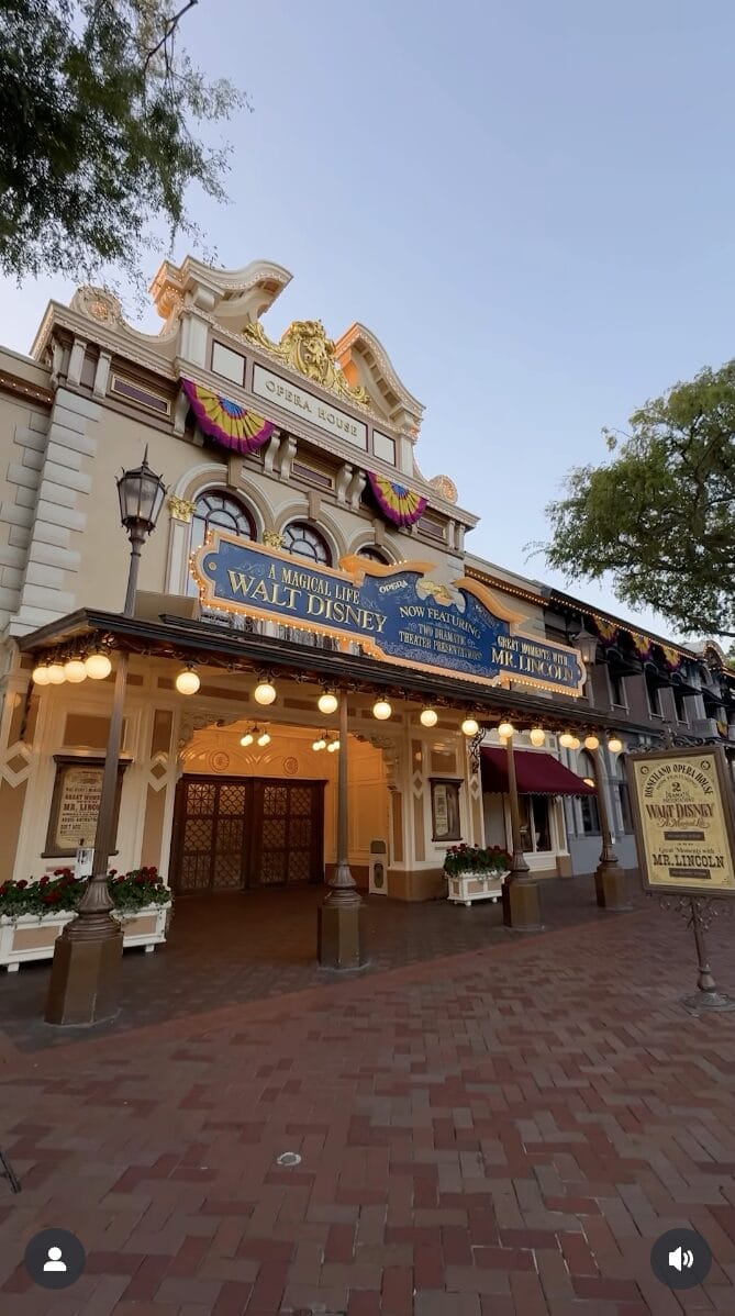Disneyland's Main Street Opera House glows at sunset with Attraction Poster banners for "A Magical Life: Walt Disney" exhibit.
