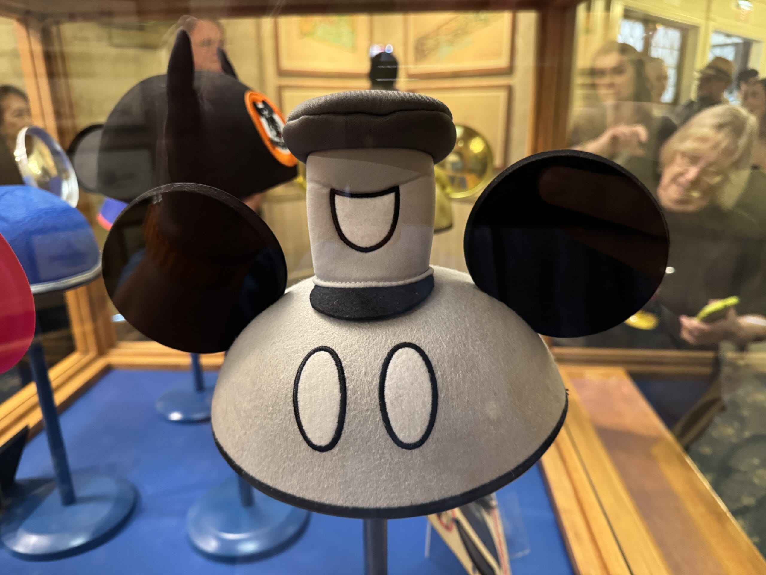 A gray Mickey Mouse ear hat with a cartoon face and buttons, featured in new exhibits at the Main Street Opera House.