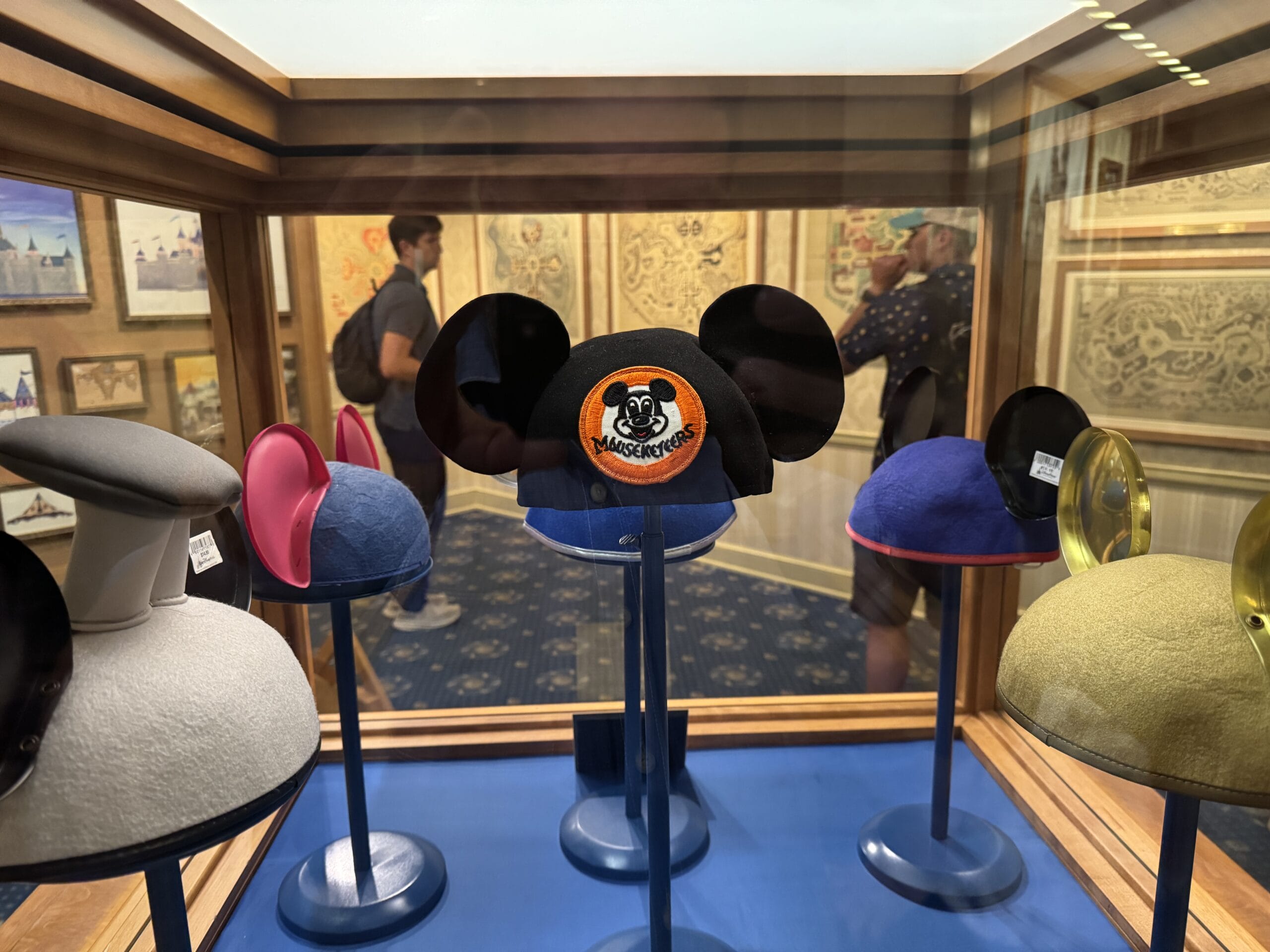 Display case at Main Street Opera House with Mickey Mouse ear hats, including a "Mouseketeers" patch, among new exhibits.