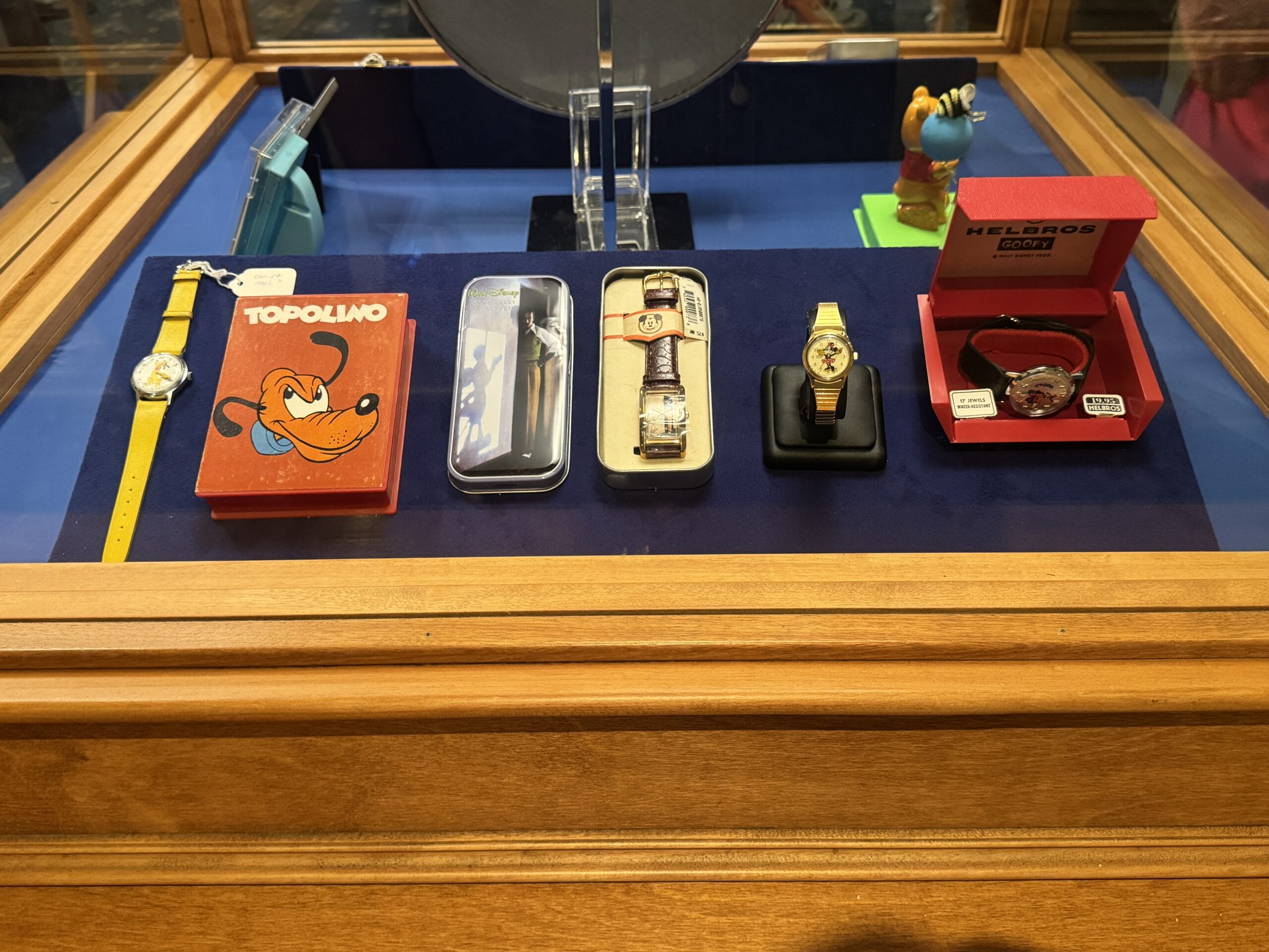 Display case with vintage wristwatches, a Topolino box, and new exhibits from the Main Street Opera House.