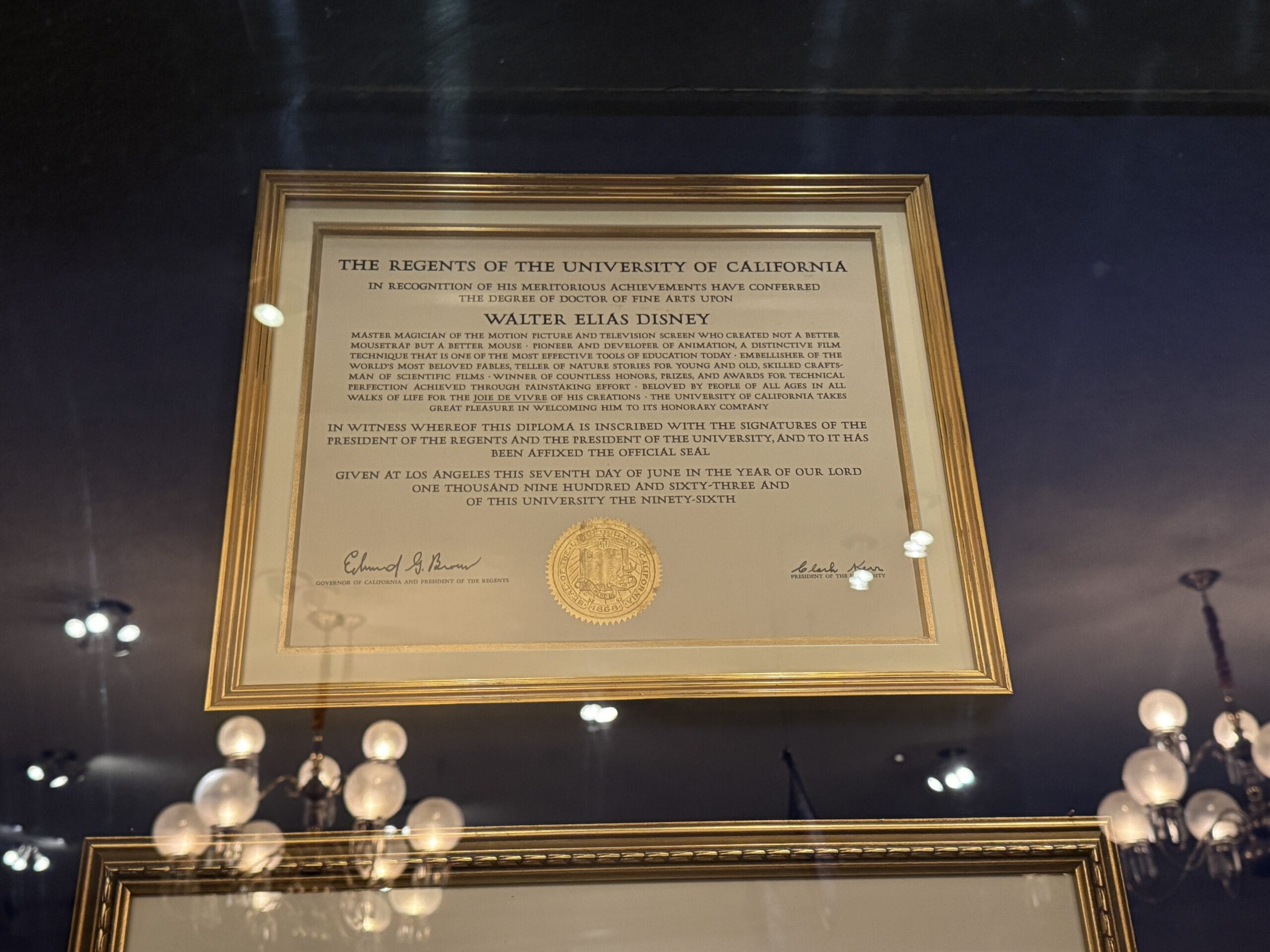 A framed honorary degree certificate awarded to Walt Disney is displayed at the Main Street Opera House.
