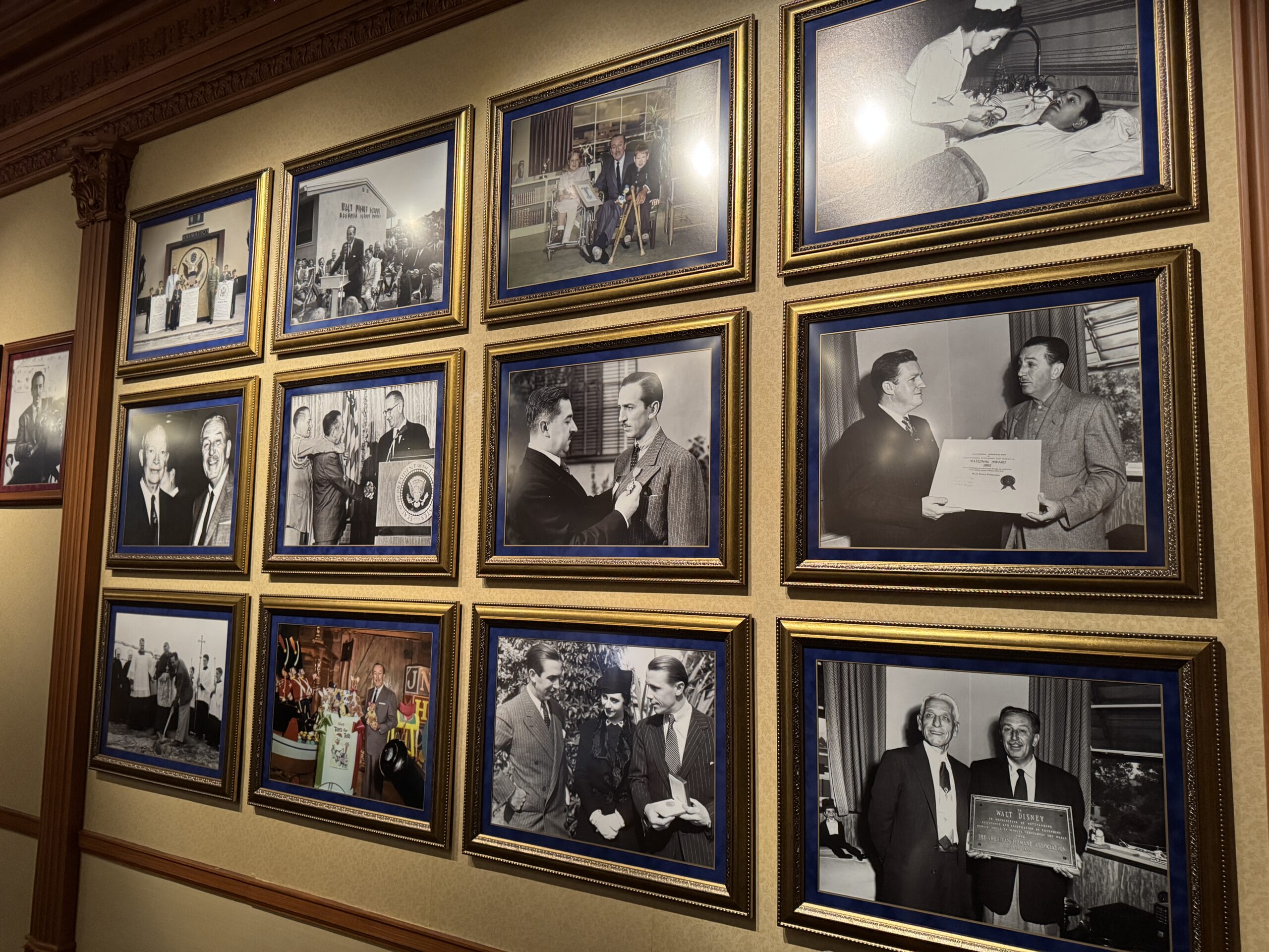 A wall at Main Street Opera House displays framed black-and-white photos of people at events and award presentations.