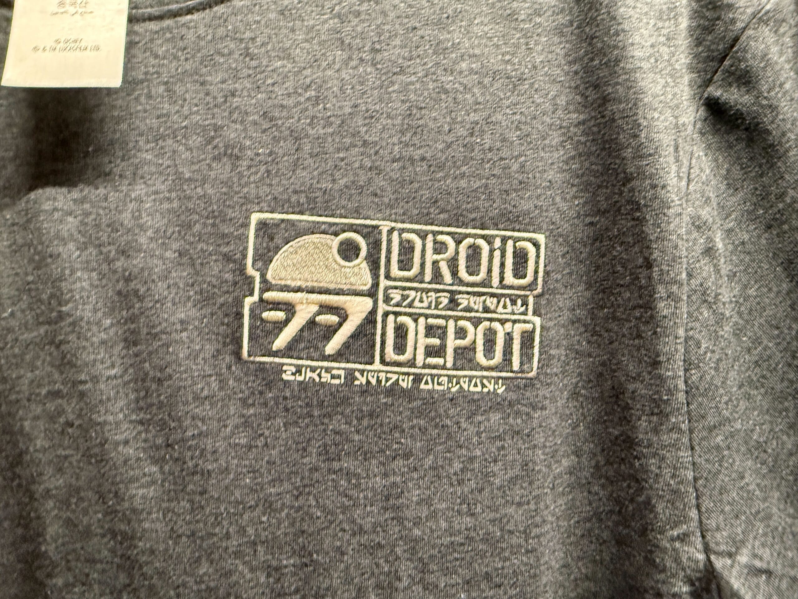 Gray shirt with "Droid Depot" logo and droid graphic, plus text in English and Aurebesh from Star Wars.