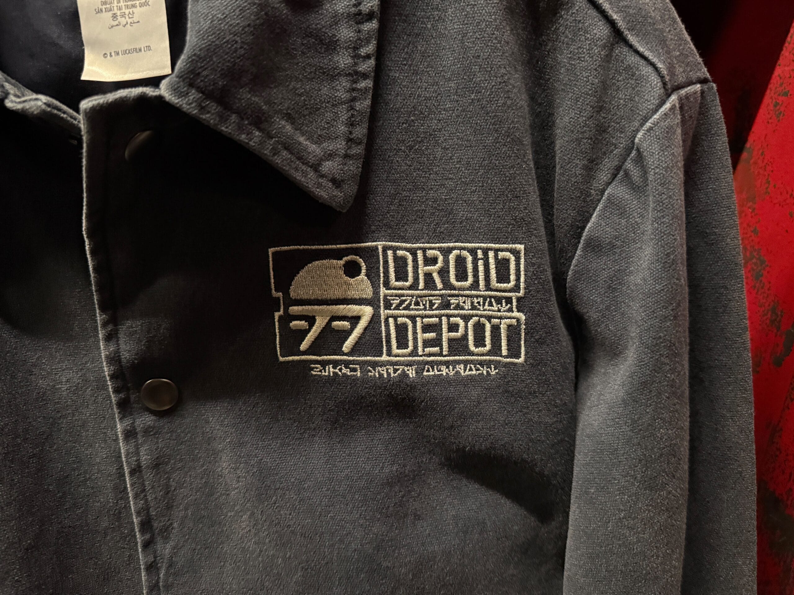 Dark gray jacket with "Droid Depot" logo and design embroidered in white on the chest.
