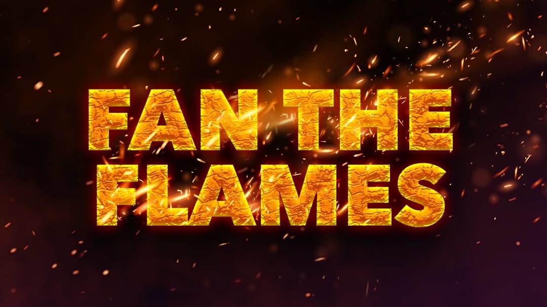 The phrase "FAN THE FLAMES" glows hot with sparks and embers, blazing against a dark Universal background.