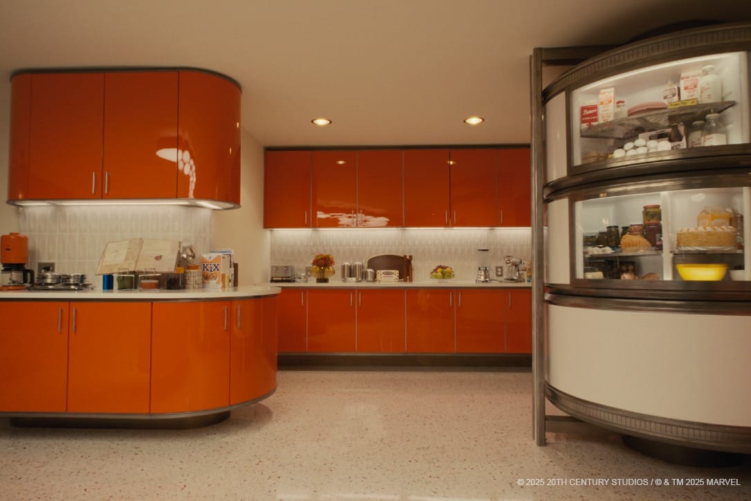 A retro kitchen with orange cabinets and a round half-open refrigerator stocked with food.