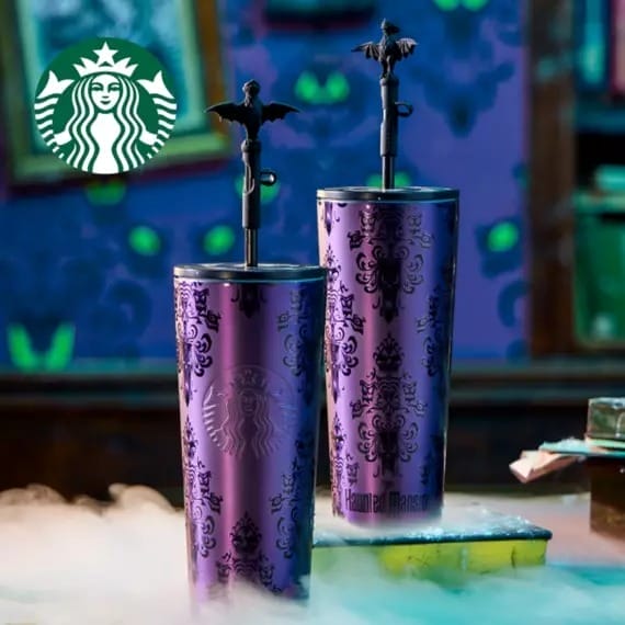 The Starbucks Haunted Mansion Tumbler 2025 with haunted mansion designs and bat straw toppers, surrounded by mist. Disney Store exclusive.