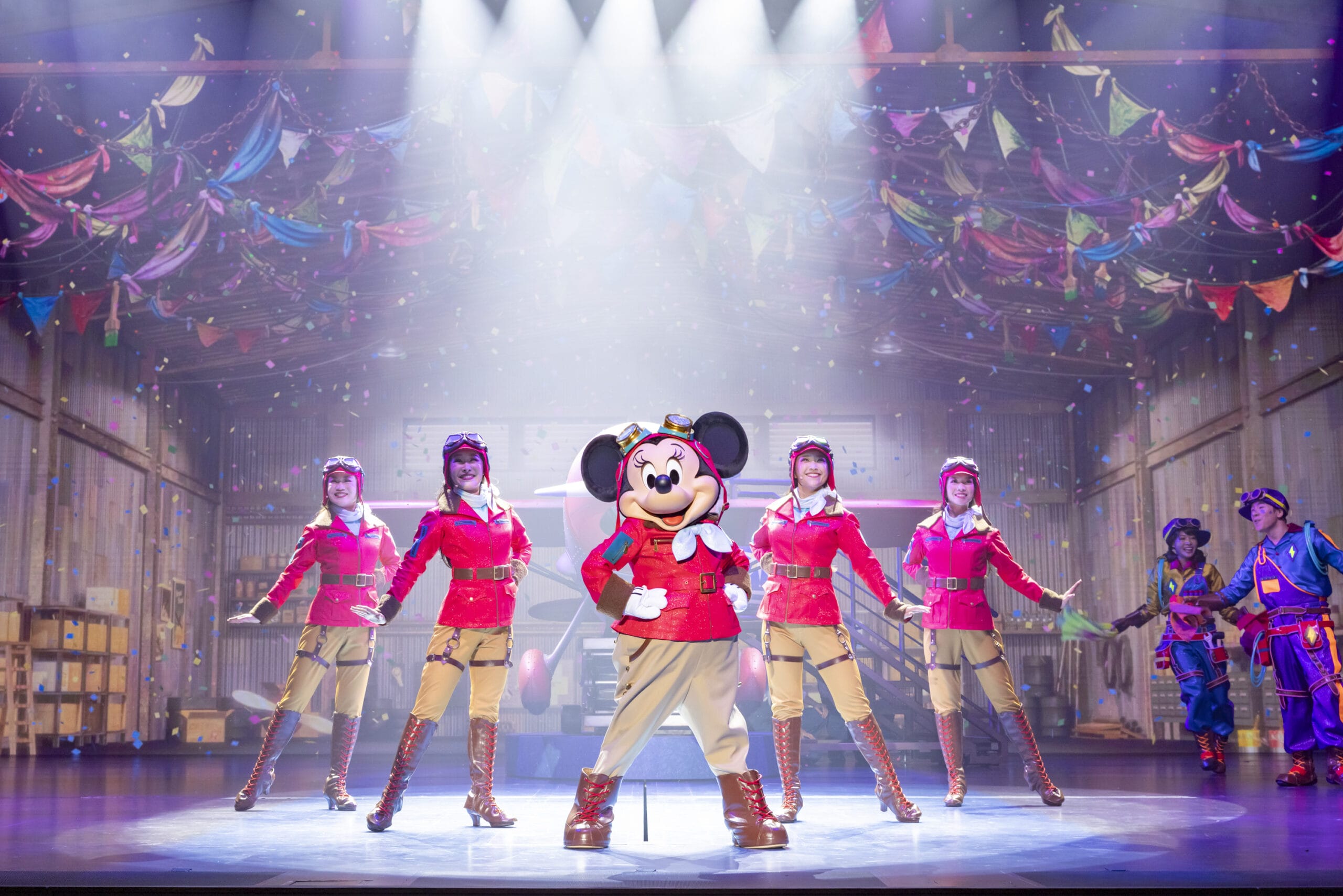 Mickey Mouse and dancers in red dazzle at Tokyo DisneySea as dreams take flight amid confetti and colorful flags.