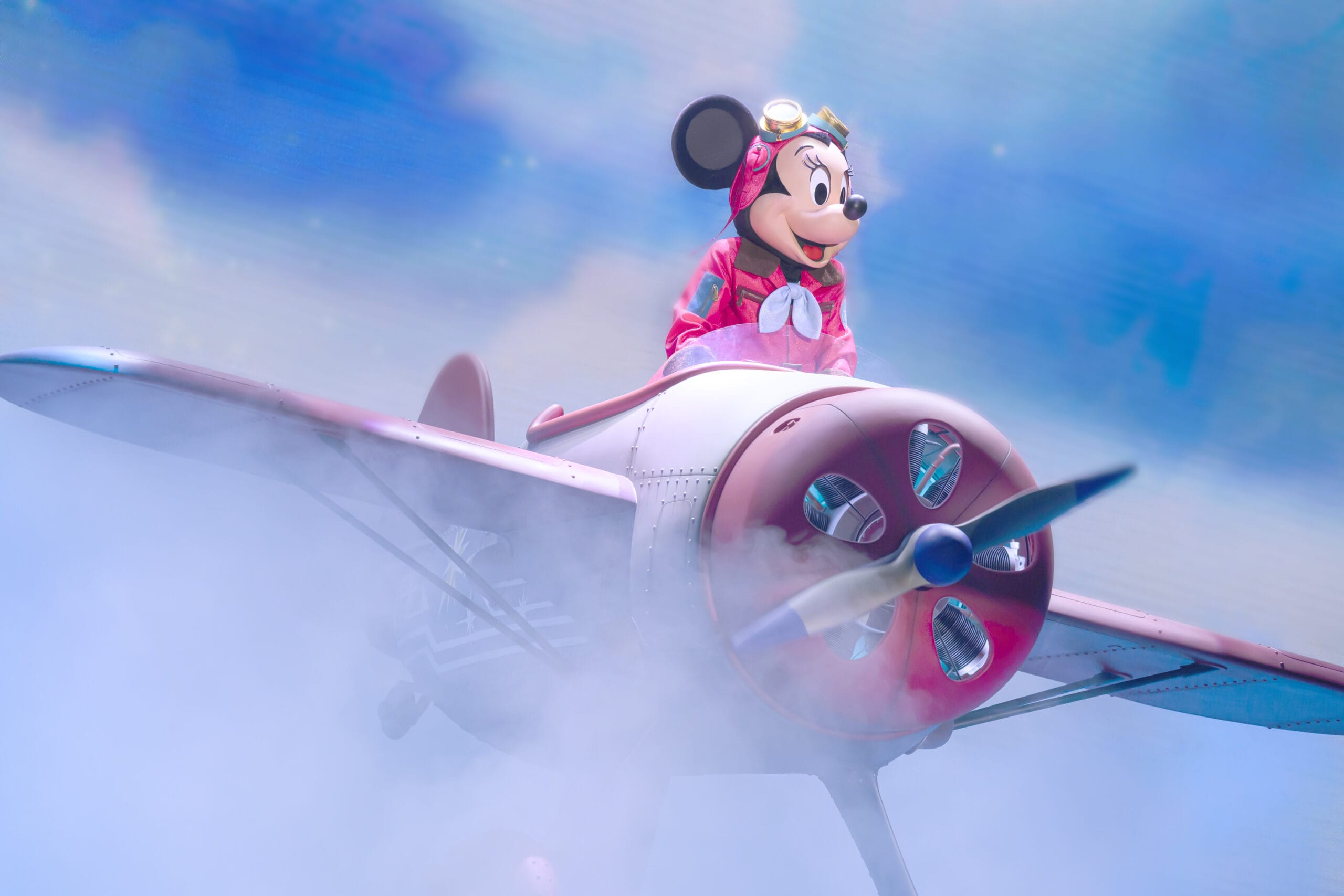 Minnie Mouse dressed as a pilot soars through the clouds at Tokyo DisneySea, where dreams take flight.