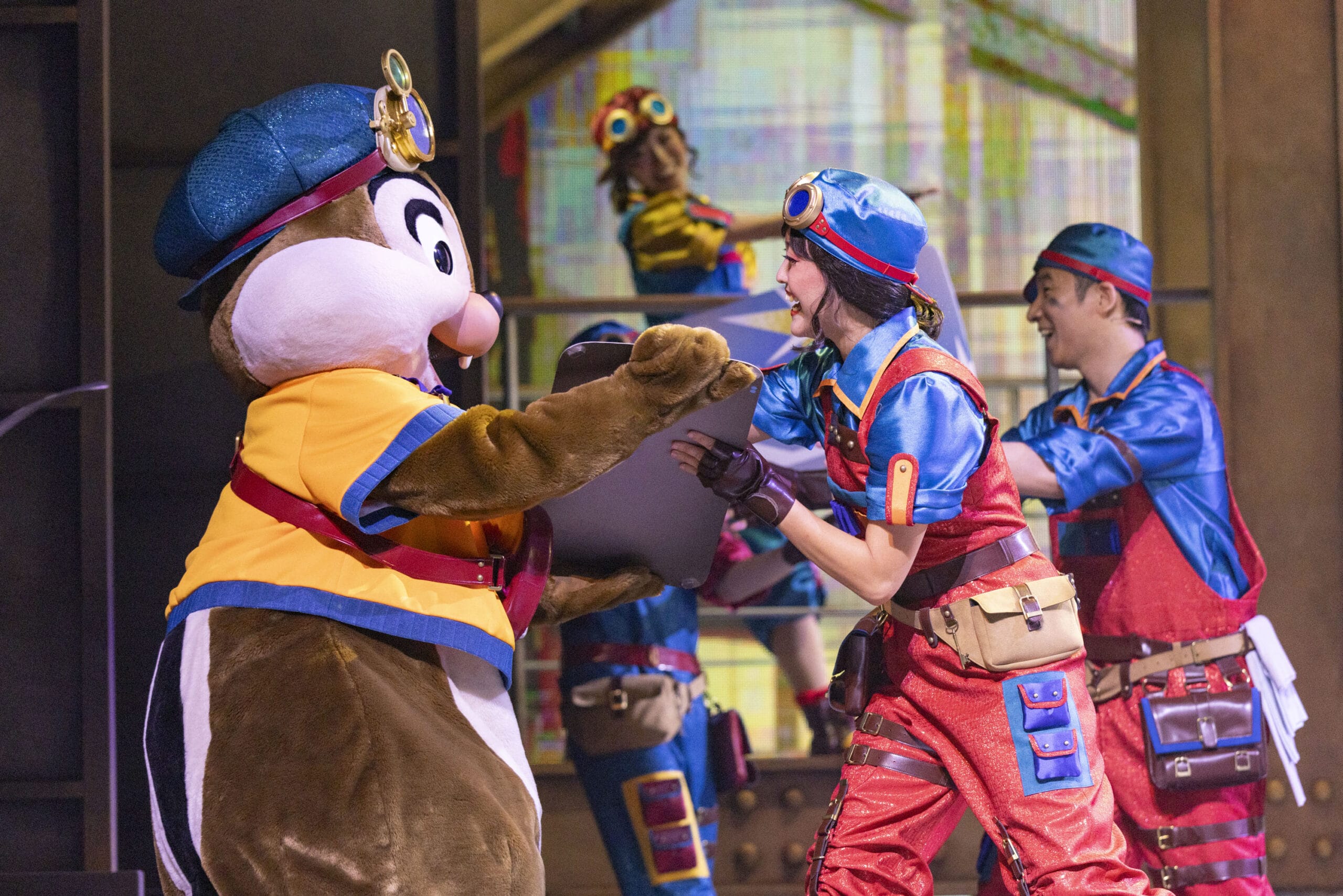 Person in a chipmunk costume shakes hands with performers as dreams take flight on a lively Tokyo DisneySea stage.