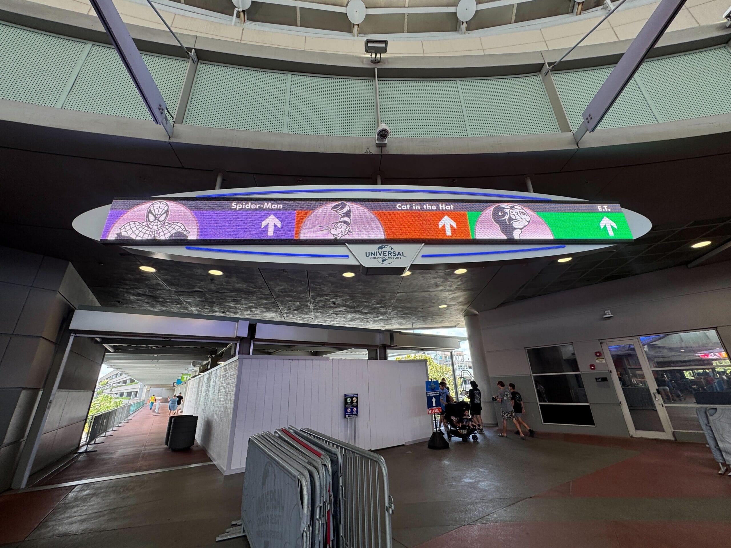 Overhead sign at Universal Studios Florida showing directions to Spider-Man, Cat in the Hat, and Hulk parking garage sections.