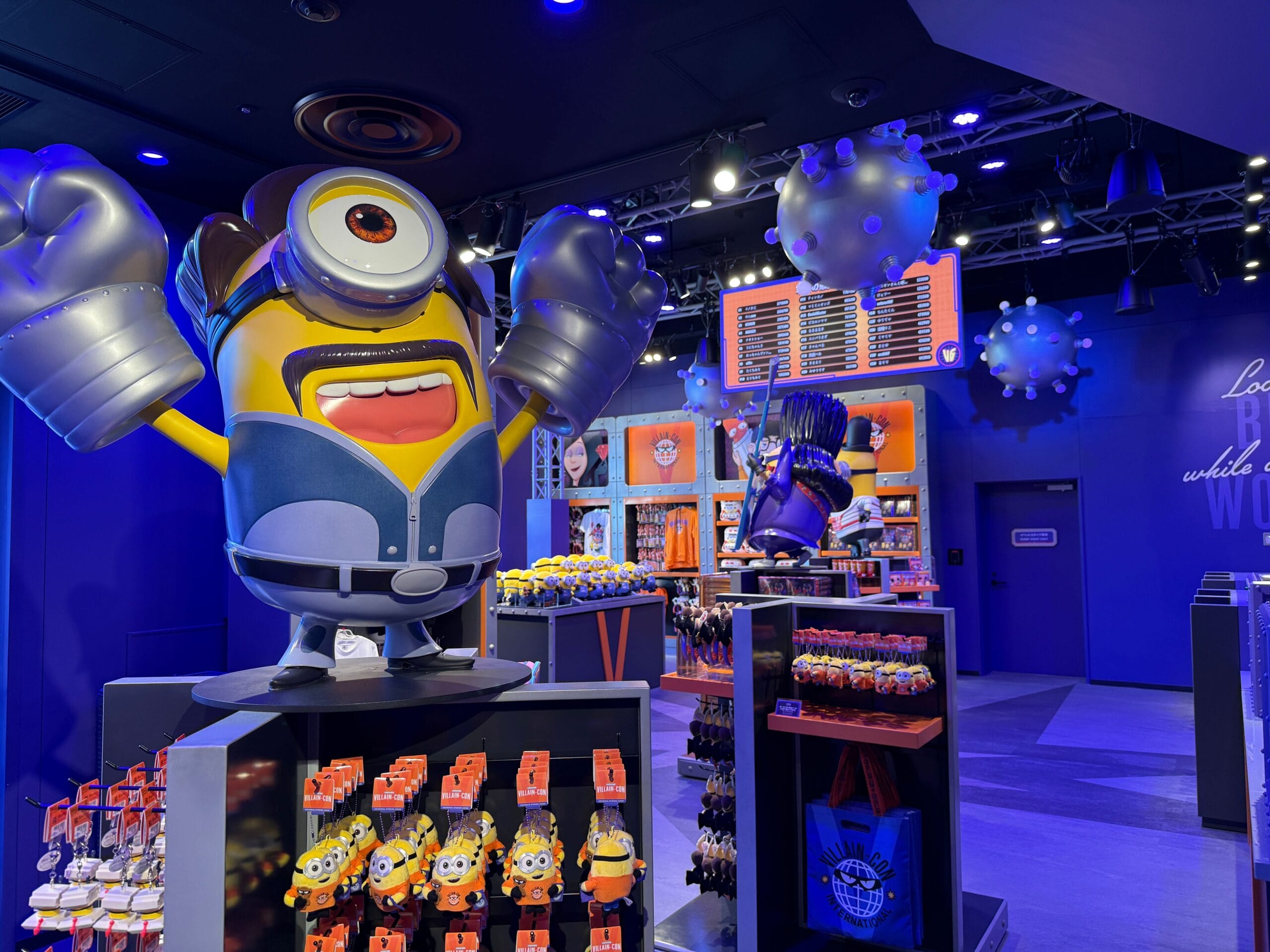A Minions-themed store displays Minion figures, toys, and merchandise under bright, colorful lighting.