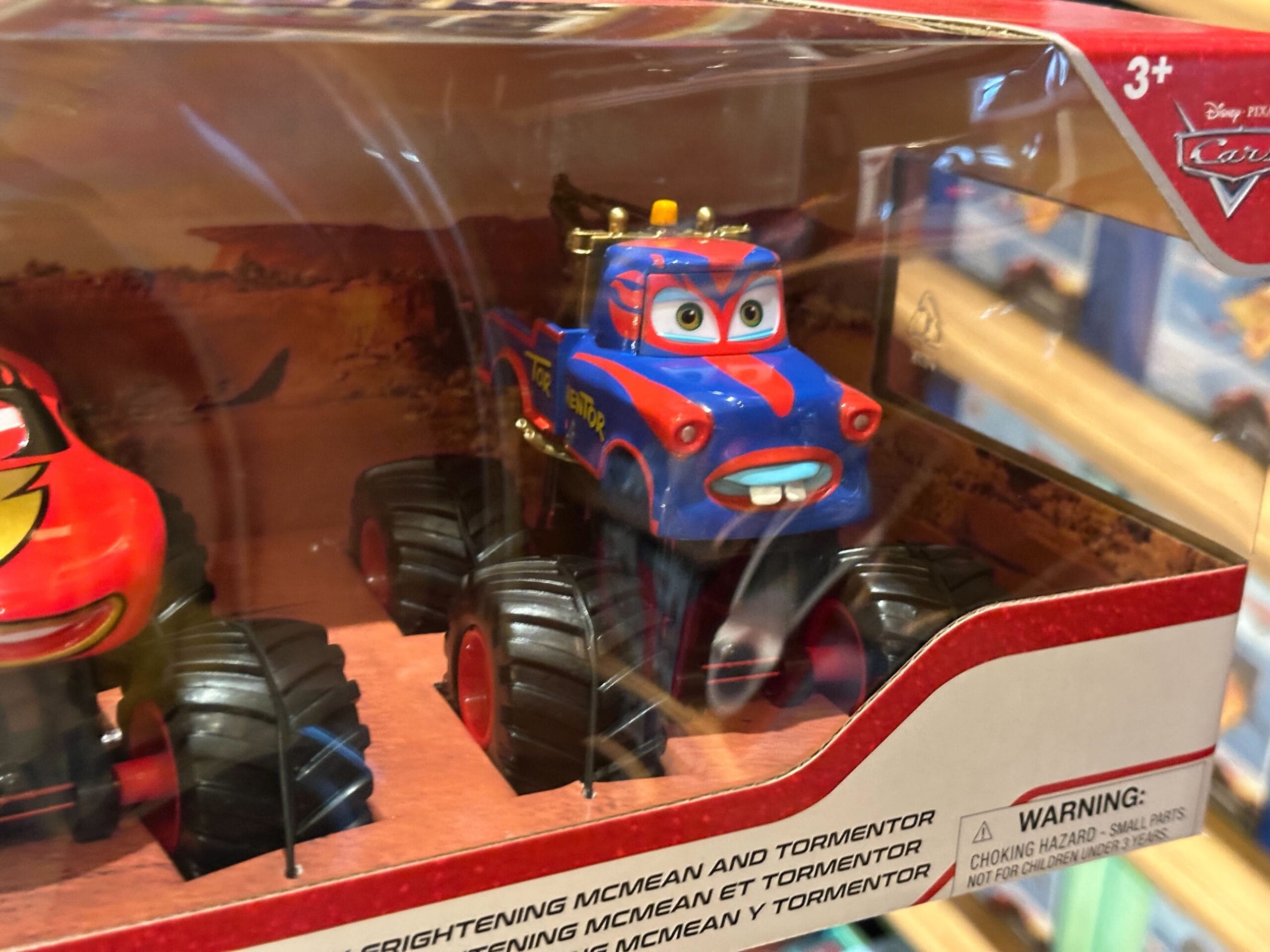A blue and red monster truck toy character from Disney Cars, displayed in packaging with clear plastic front.