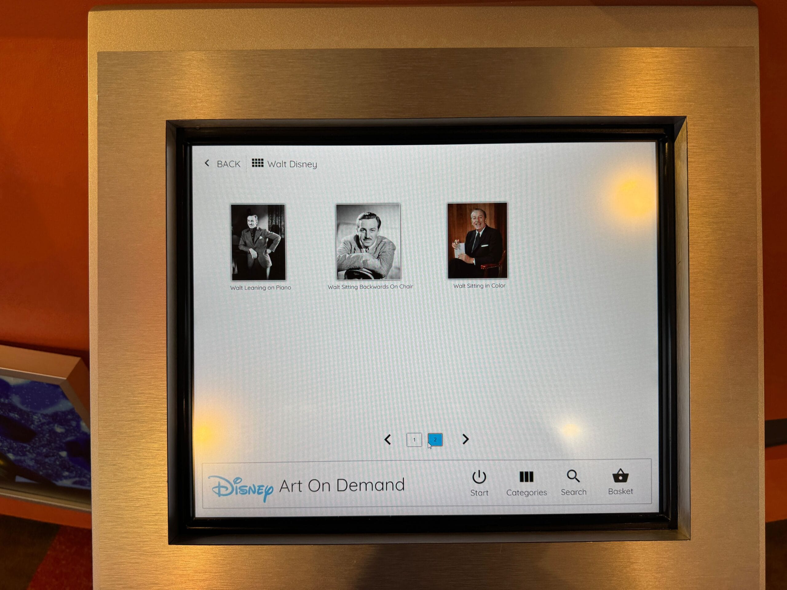 A touchscreen display shows three black-and-white photos for Disney Art On Demand: Walt Disney in various poses.