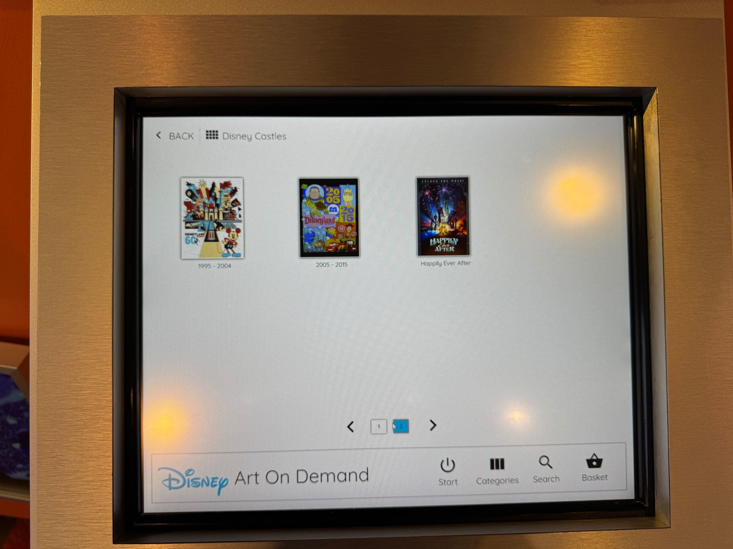 A screen displays three Disney castle art prints for sale at Bayview Gifts in Disney's Contemporary Resort.