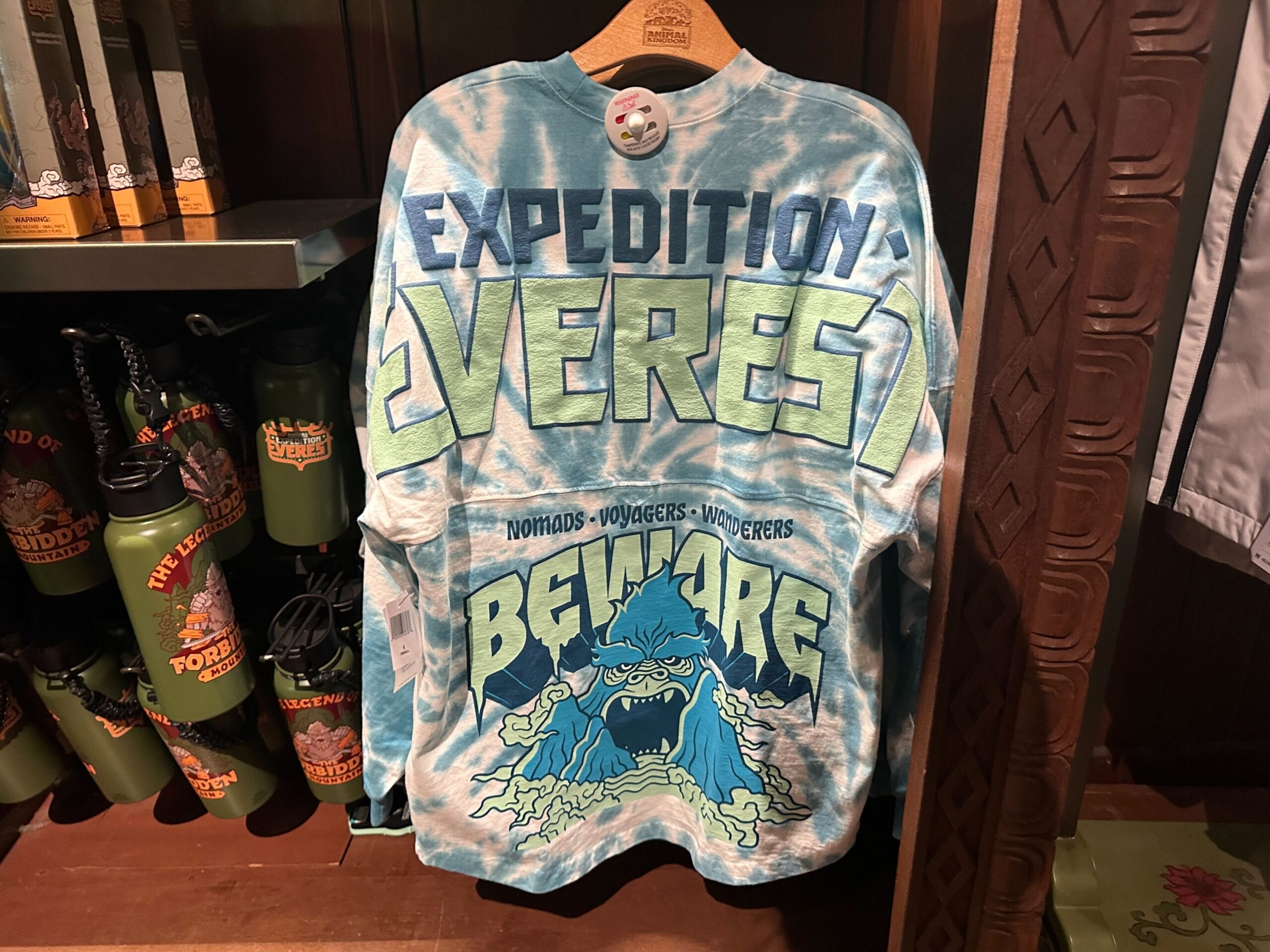 A blue tie-dye shirt reads "Expedition Everest" and "Beware" with a graphic of a roaring yeti.
