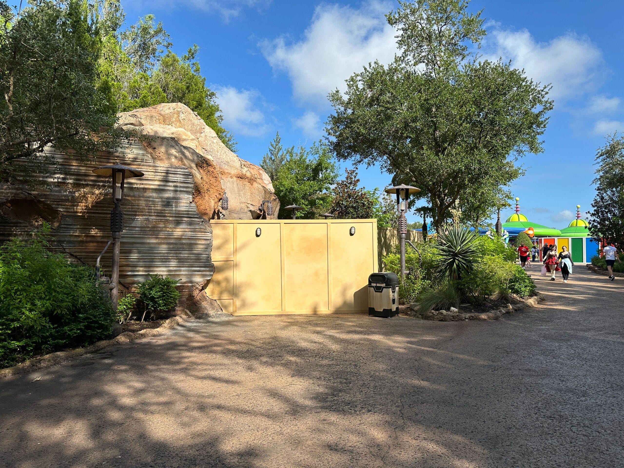 New construction walls block a path at Disney's Hollywood Studios near Star Wars Galaxy's Edge, with people walking by.