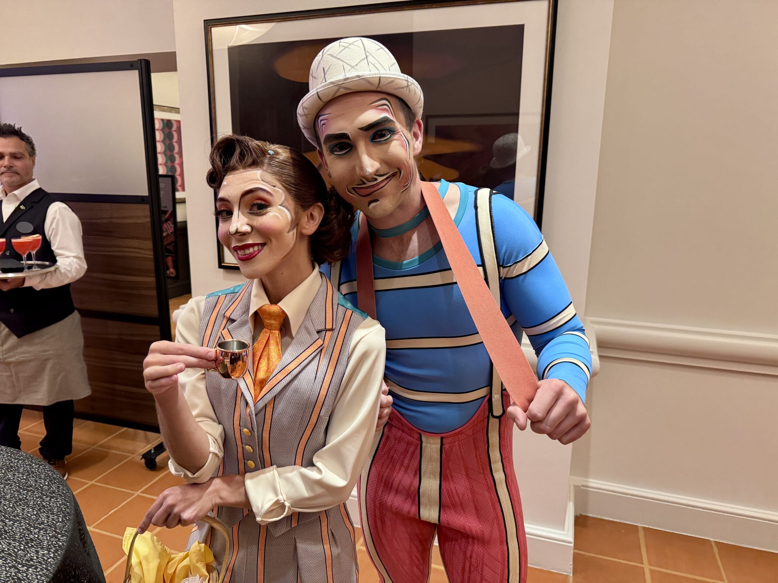 Two performers in vintage costumes pose and smile at a Bourbon Steak event in the Walt Disney World Dolphin Hotel.