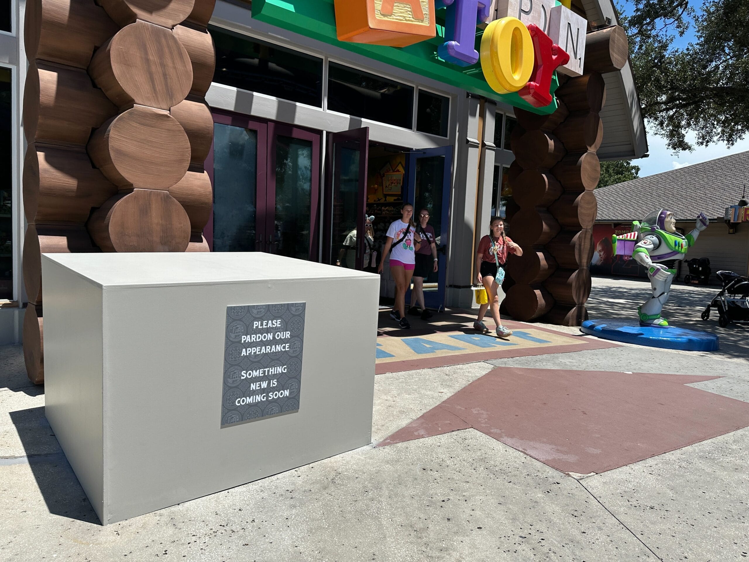 A covered display where the missing statue of Mr. Potato Head once stood at Disney Springs reads, "Pardon our appearance.