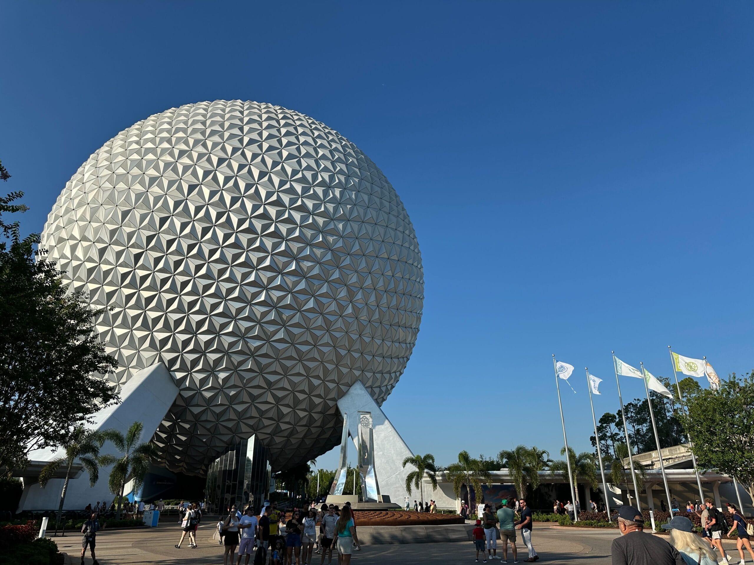 EPCOT’s geodesic sphere at Disney World stands tall under a Central Florida sky as visitors gather below.