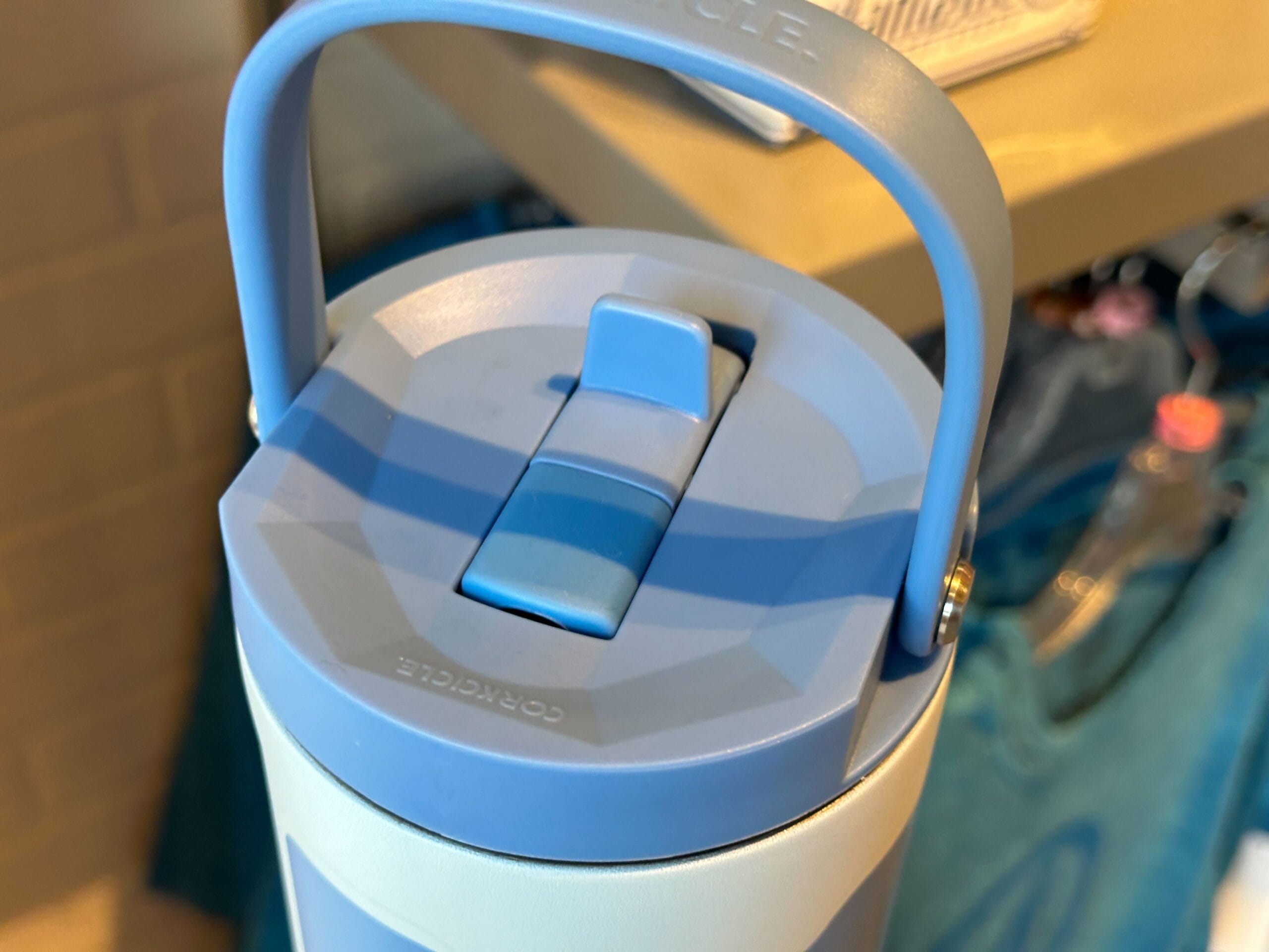 Close-up of a blue and white water bottle lid with a flip-up spout, perfect for Marvel Merchandise fans.