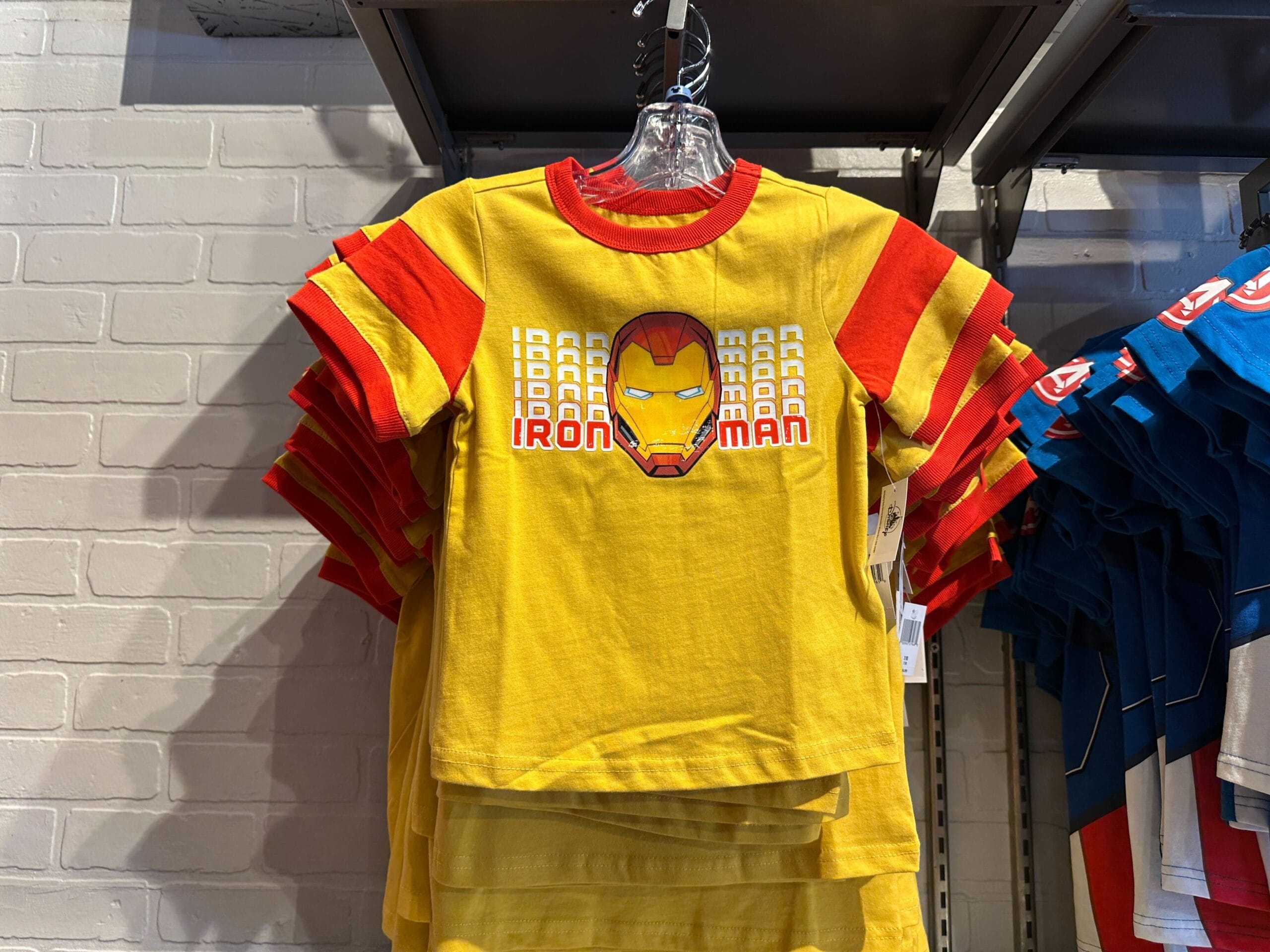 Youth Avengers Apparel: Yellow and red Iron Man t-shirt for kids, featuring Iron Man's mask and "IRON MAN" text.