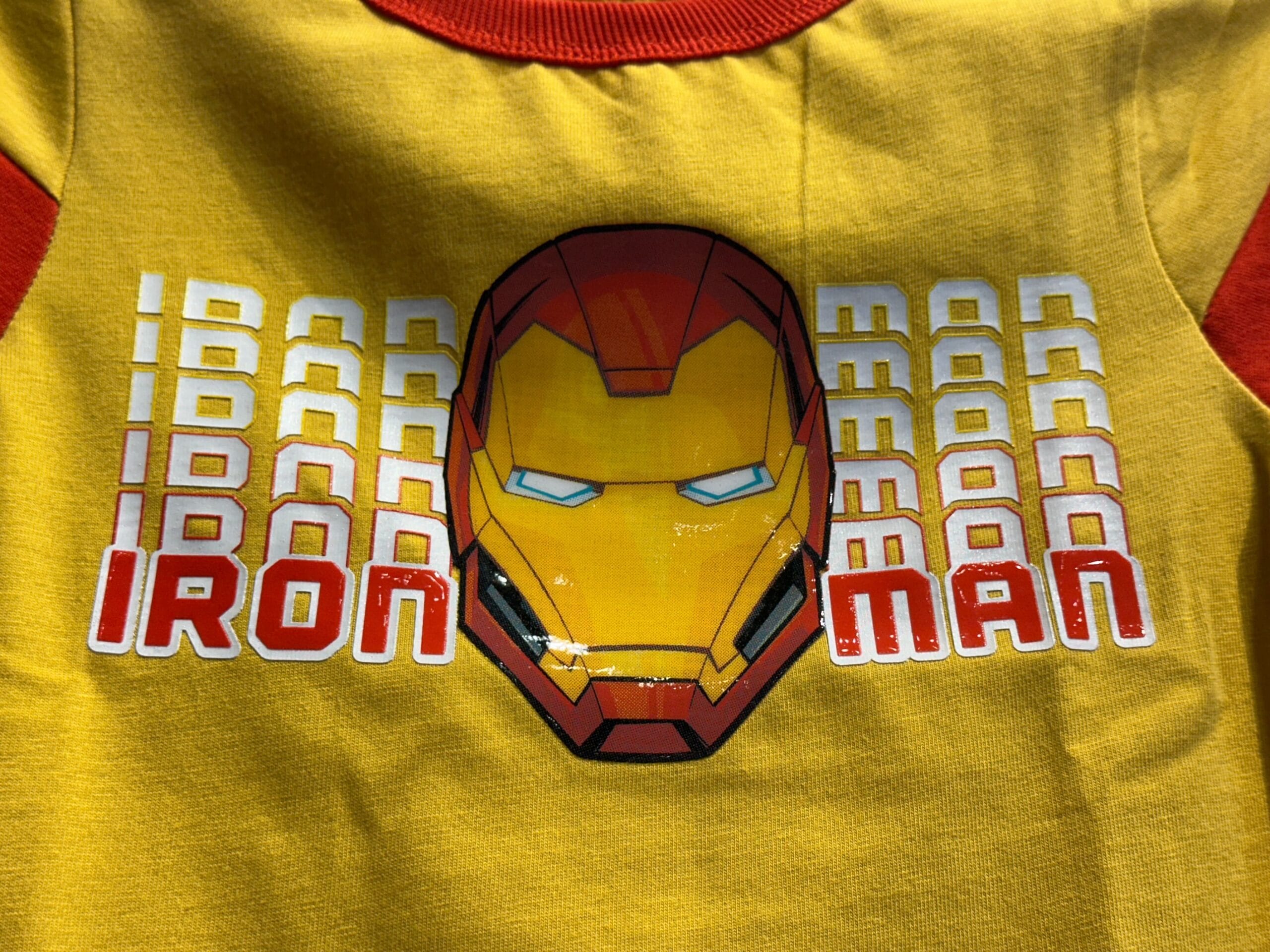 Youth Avengers Apparel: Yellow shirt with Iron Man helmet, repeated "IRON MAN" text, and bold red "IRON MAN" below the helmet.