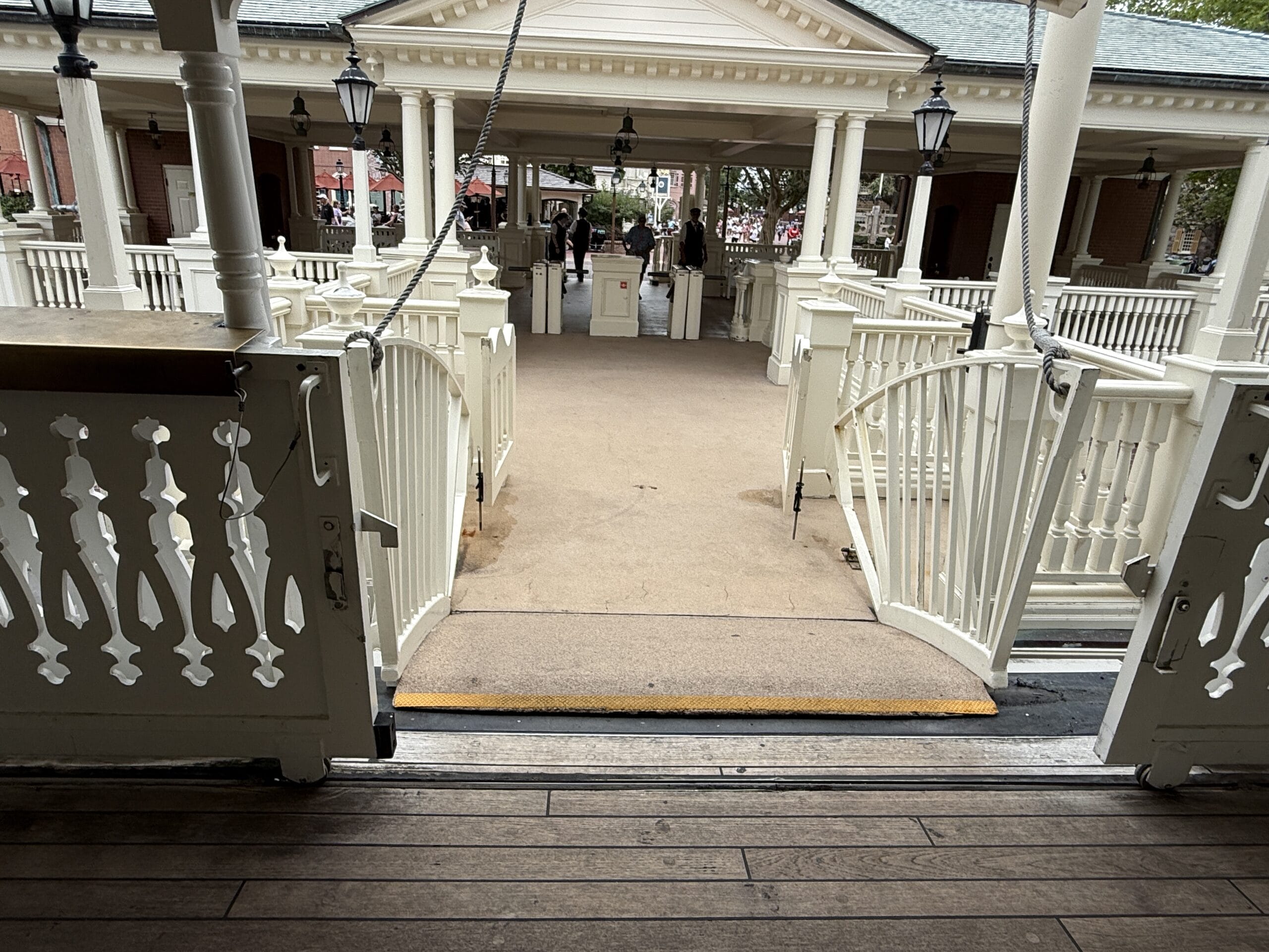 A view from the ferry dock faces a ramp leading to a white pavilion at Magic Kingdom's Liberty Square Riverboat.