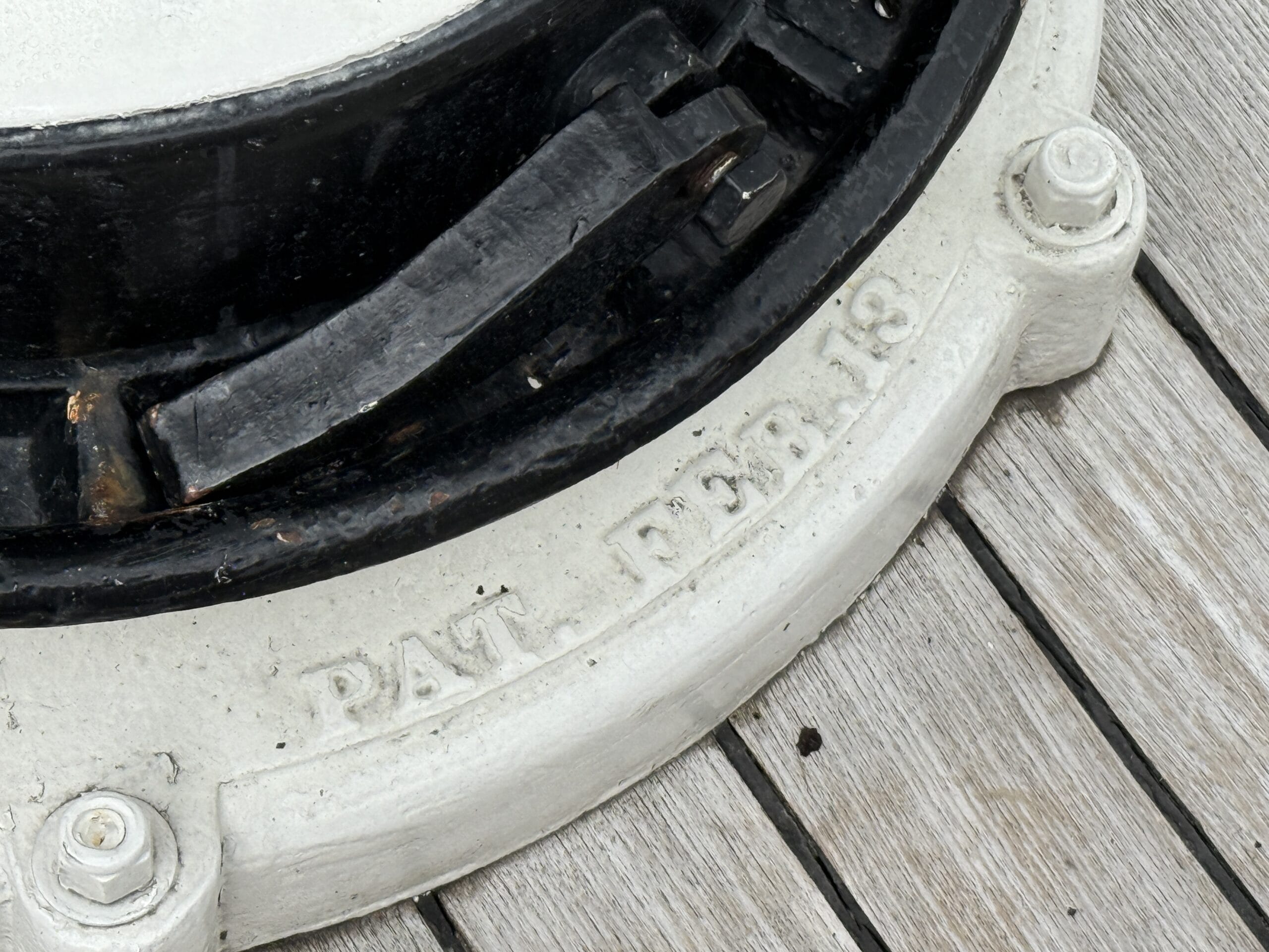 Close-up of a white metal fixture on the Liberty Square Riverboat, embossed with "PAT. FEB. 18," at Magic Kingdom.