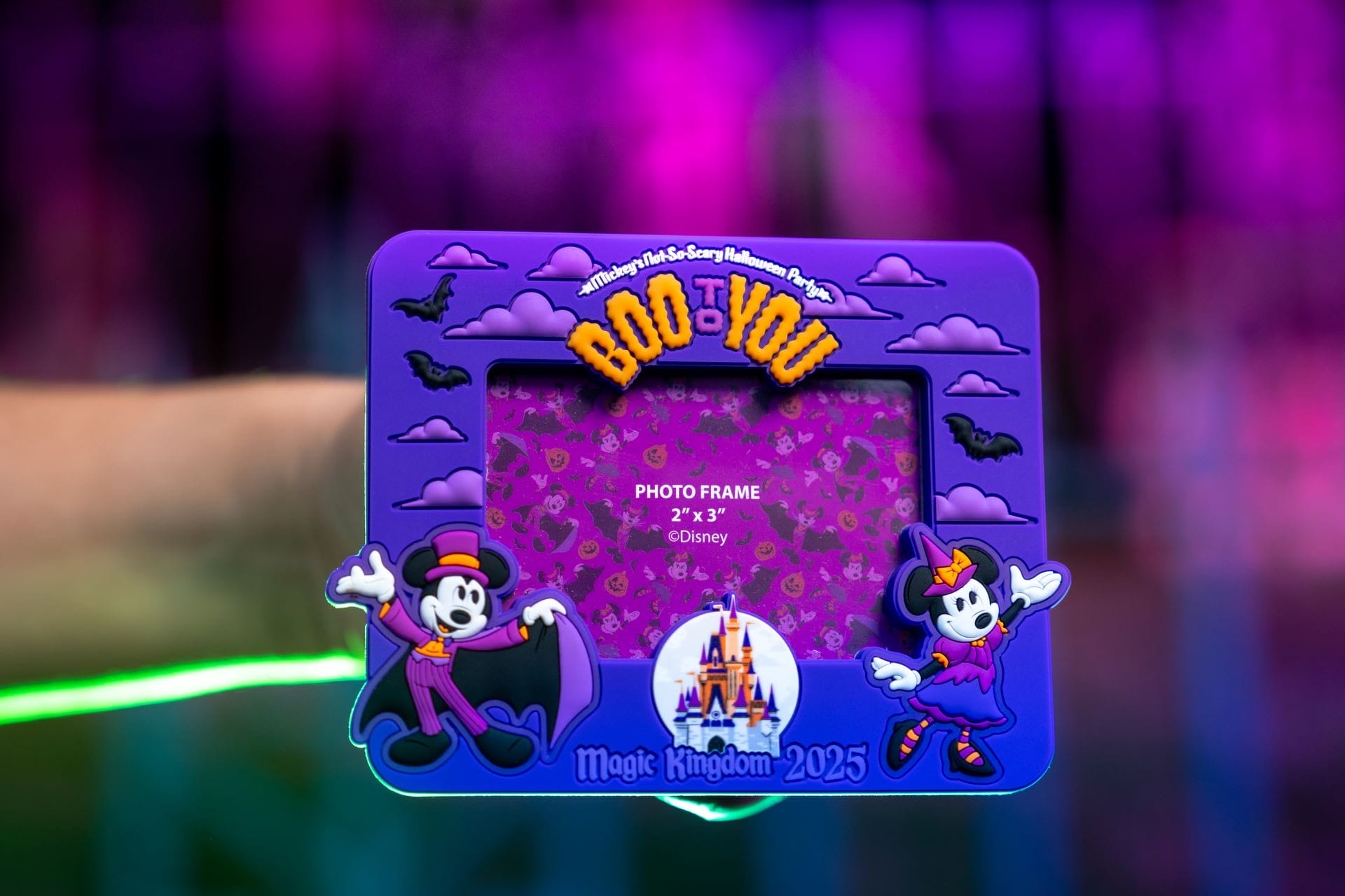 A hand holds a purple "Boo to You" Disney photo frame—fun Halloween merchandise from Magic Kingdom 2023.