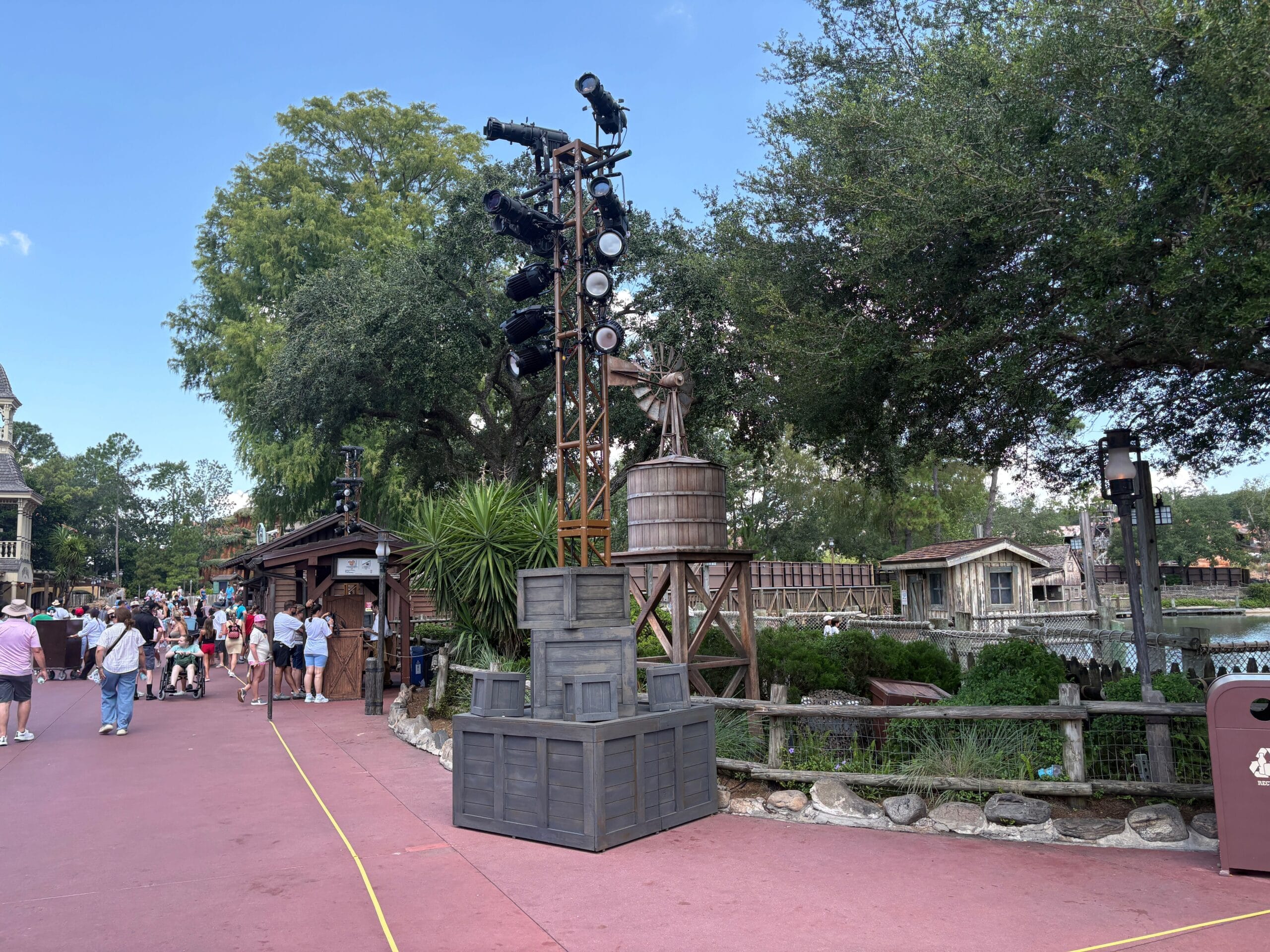 Outdoor stage lights on new trusses with stacked crates, near trees for Mickey's Not-So-Scary Halloween Party.