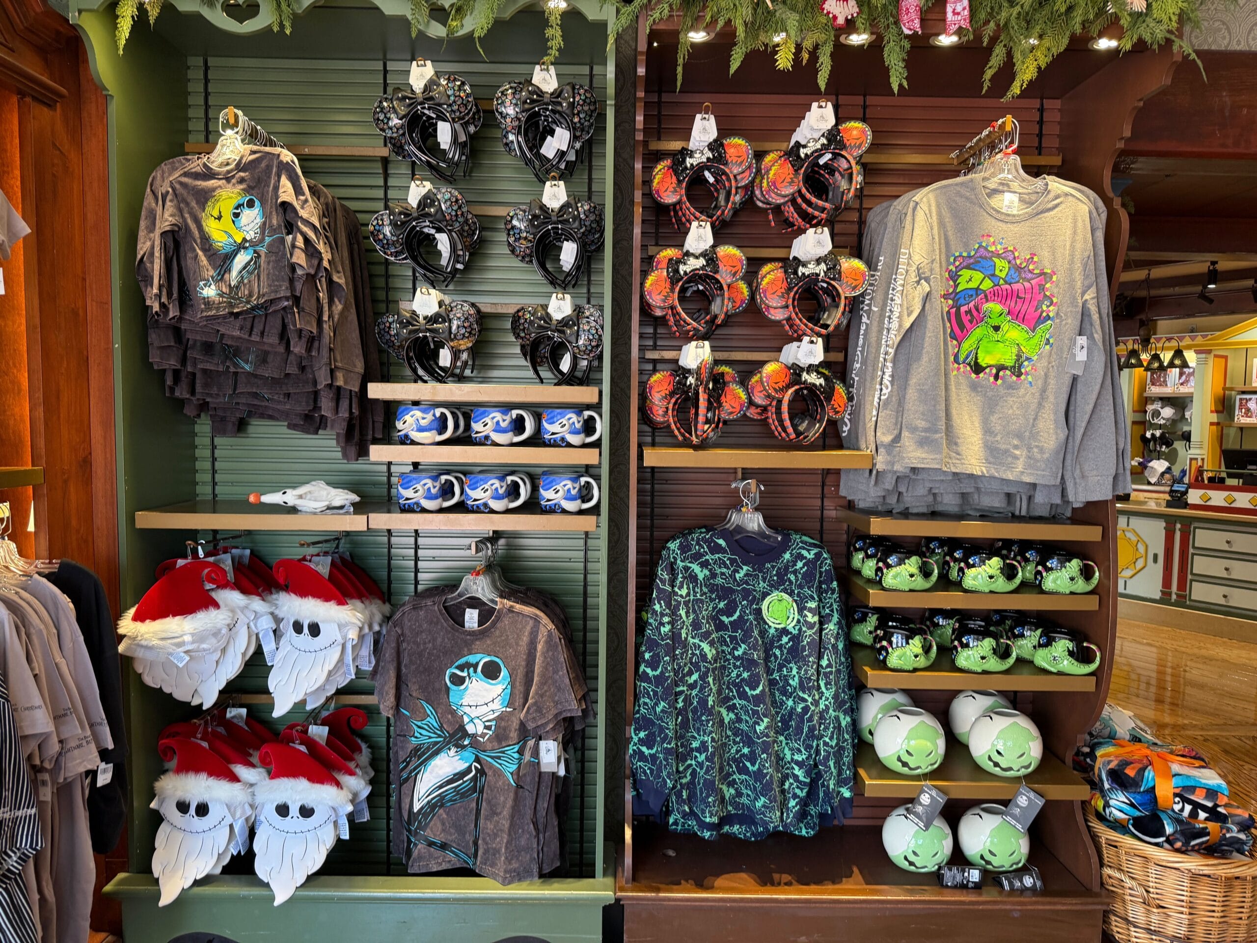 Display of Disney-themed shirts, hats, and toys with new Nightmare Before Christmas merchandise and Toy Story Alien designs.
