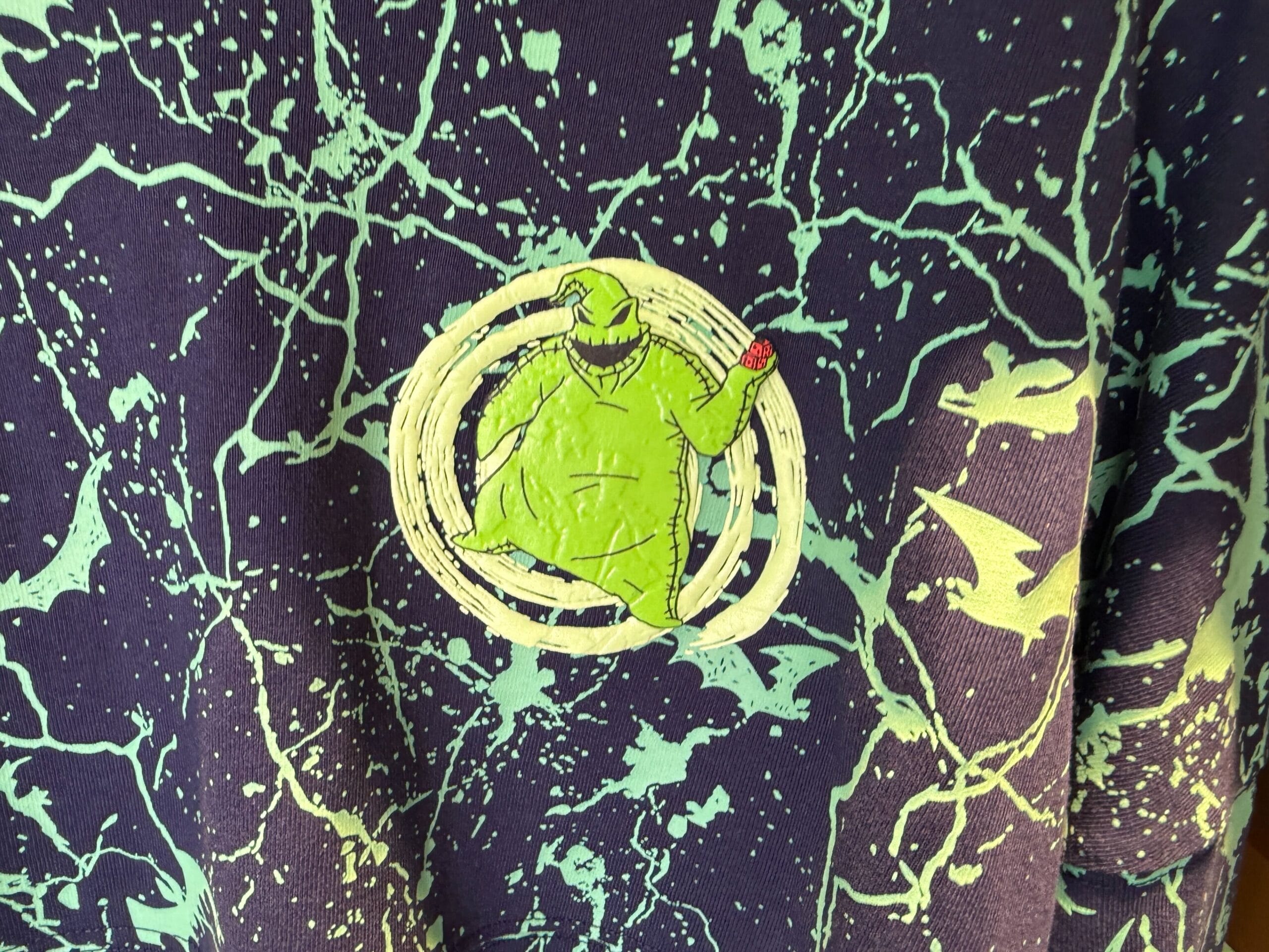 Green ghostly figure with a red dice stands on a dark background—The Nightmare Before Christmas merchandise vibes.