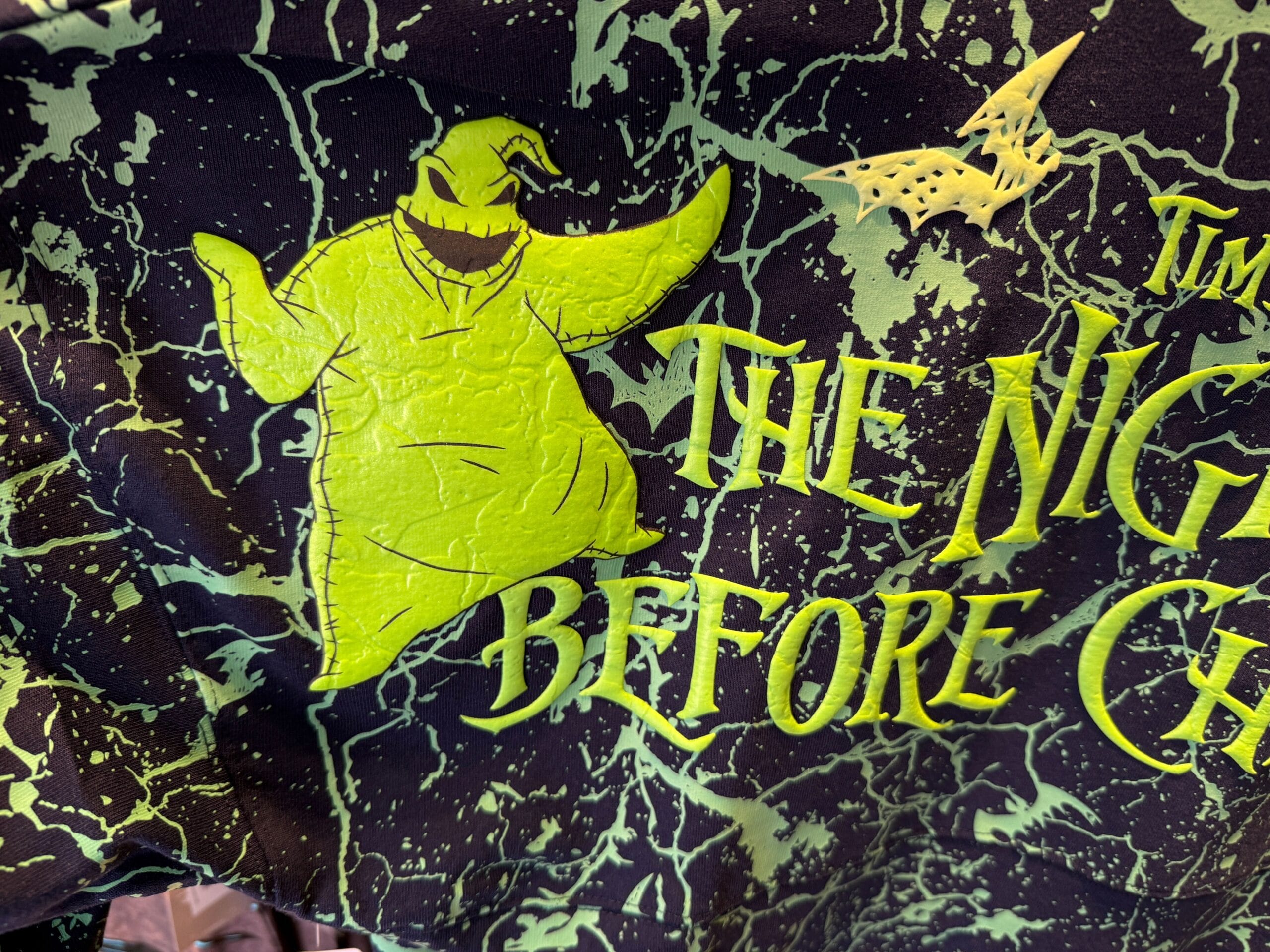New Nightmare Before Christmas merchandise: bright green Oogie Boogie and bats on black with yellow text.